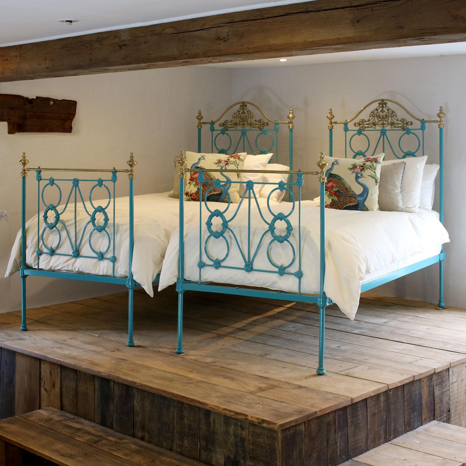 A matching pair of twin brass and iron antique beds with cast iron panels, ornate brass castings and serpentine brass top rails on the head ends, finished in striking turquoise blue.
These beds accept 3ft wide (36 inch or 90 cm) bases and