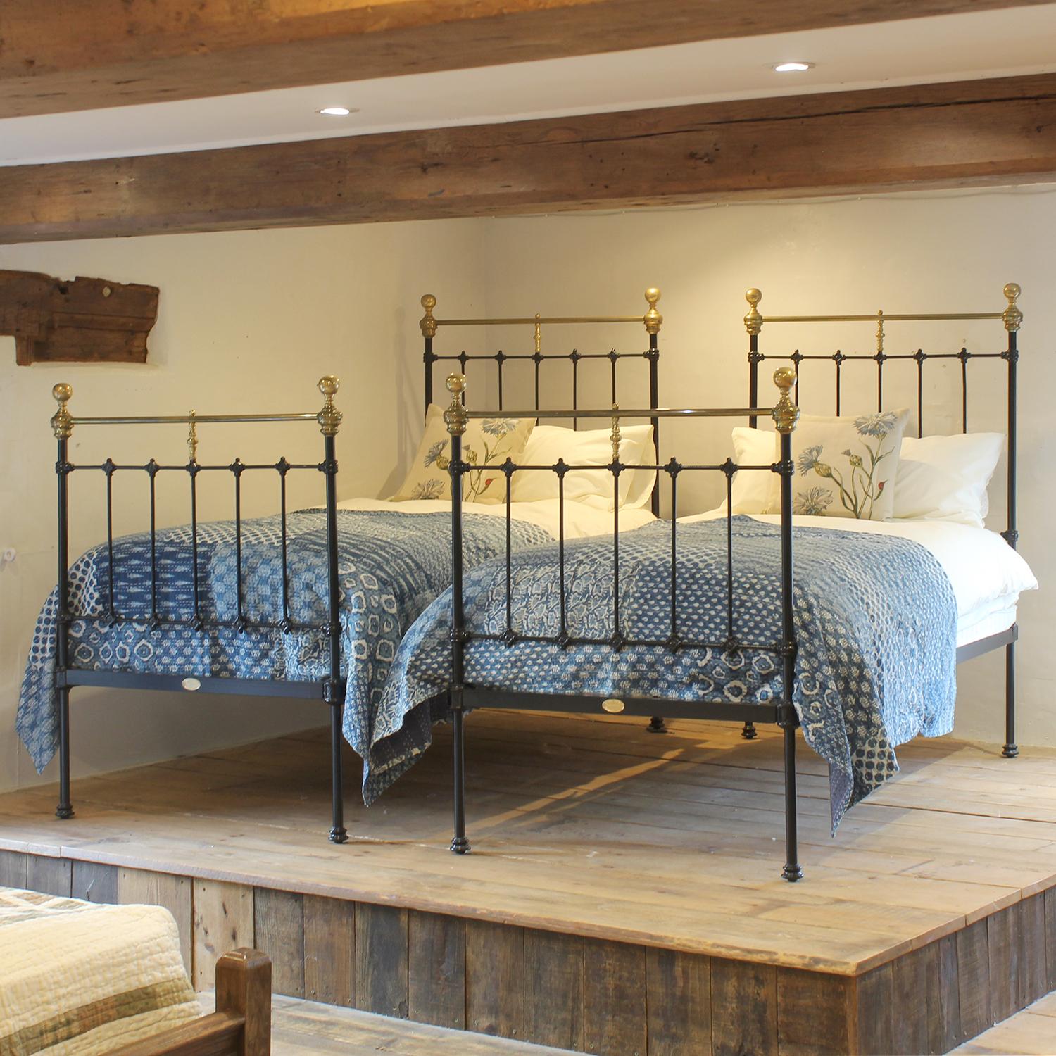 A matching pair of antique iron single beds from the late Victorian era, circa 1880, finished in black with straight brass top rails and round knobs.

These beds accept standard UK single size 3'0
