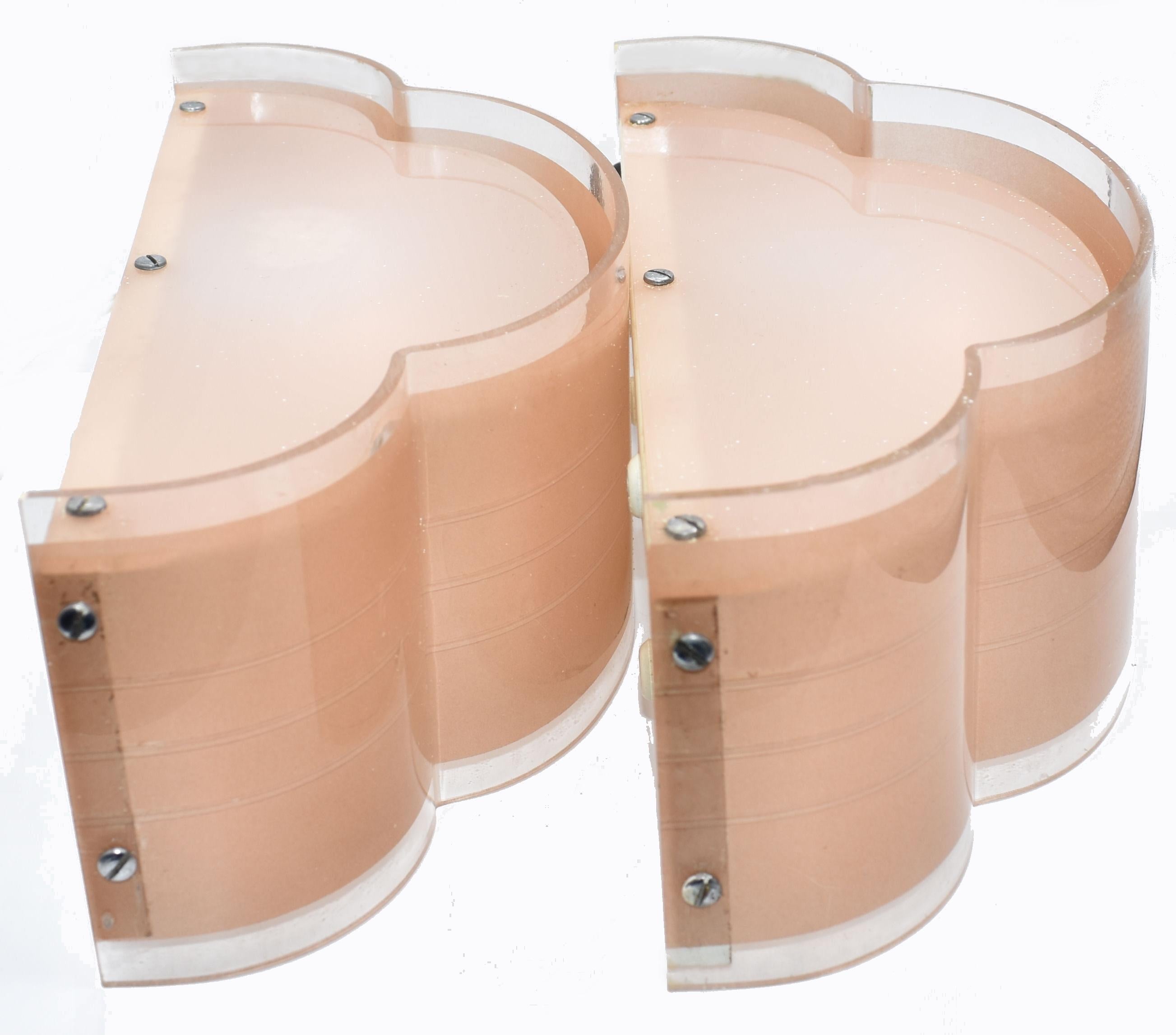 Un'ottima occasione per possedere una favolosa coppia di applique rosa tenue originali degli anni '30 in Inghilterra. Stampato in plastica precoce/perspex con piastre posteriori in metallo, la forma è a nuvola e ha un aspetto molto odeonesco. Le