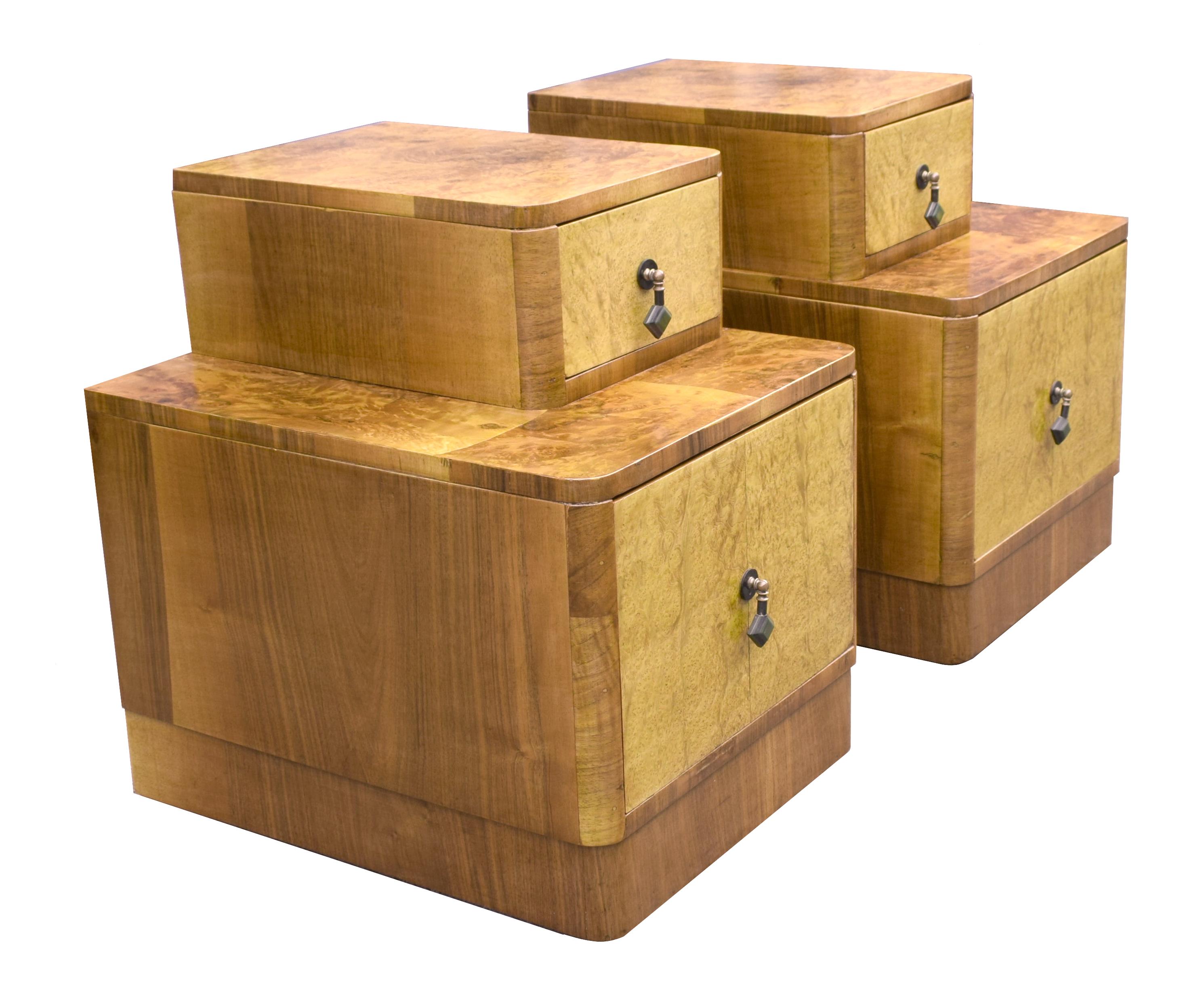 Very ironically shaped pair of 1930s Art Deco night stands, originating from England. Beautifully figured Walnut veneers with figured blonde ash drawer fronts. These cabinets still retain their original green and black bakelite drop handles. Two