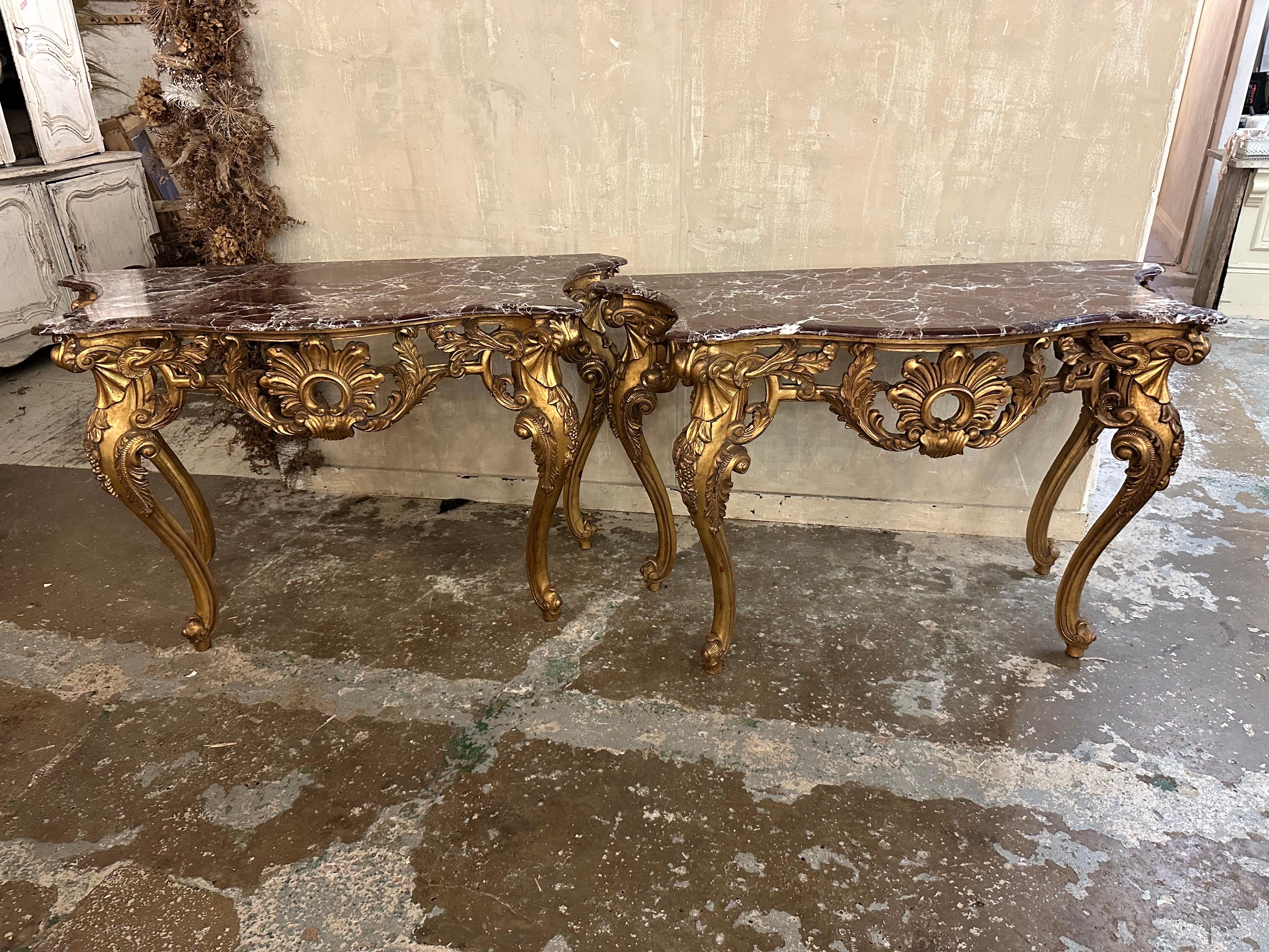 Beautiful matching pair of French console tables with decorative legs and marble tops. 