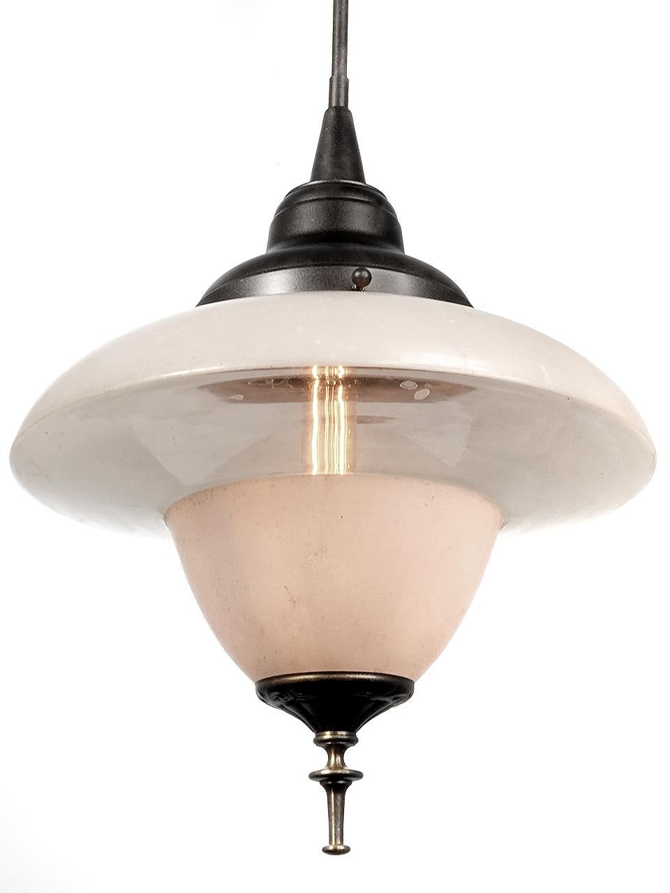 This is a nice matching pair of saucer pendents. The glass is an interesting combination frosted and clear glass. Note that the glass itself has no color and will take on the bulbs color. This lamp has some nice brass detail at the bottom of the