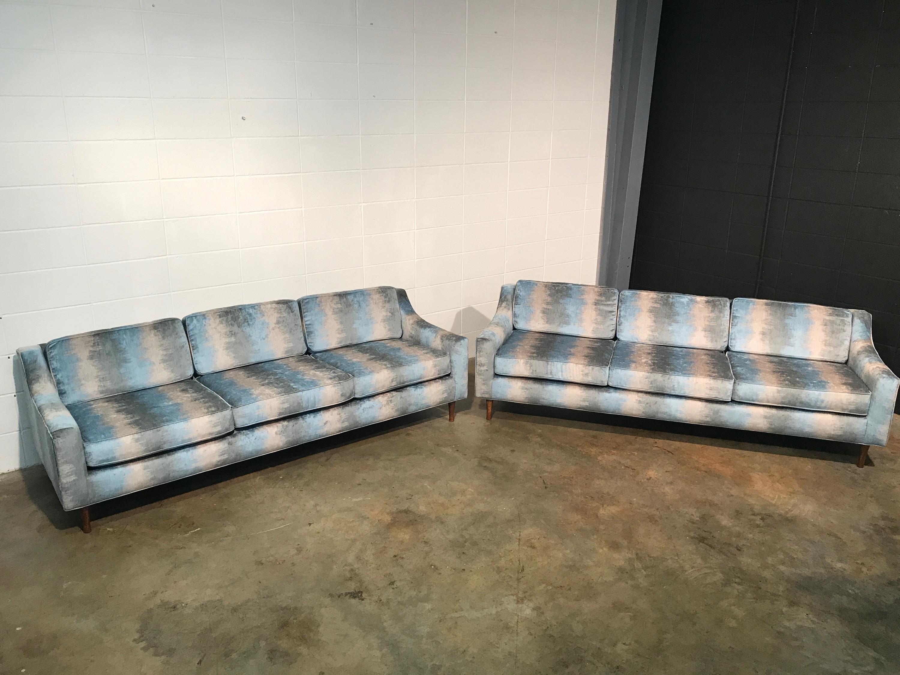 Matching pair of fully restored Mid-Century Modern vintage sofas.
Full restoration includes all new high density foam, new fabric, and wooden legs refinished. Fabric is a Flame Stitch style pattern that is mostly blue and gray in color. See photo