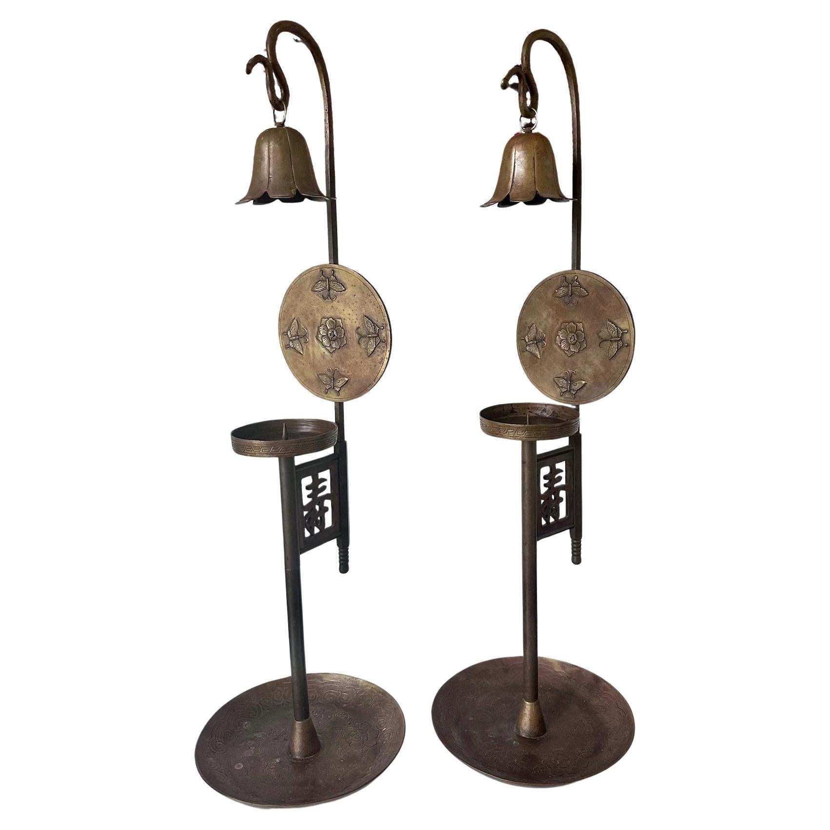 Coppia di candelieri alti e coordinati realizzati in ottone massiccio, provenienti dalla Corea del 1900 circa (fine della dinastia Joseon). Il candeliere è composto da tre sezioni: un grande vassoio di base con un tubo centrale in cui viene inserita