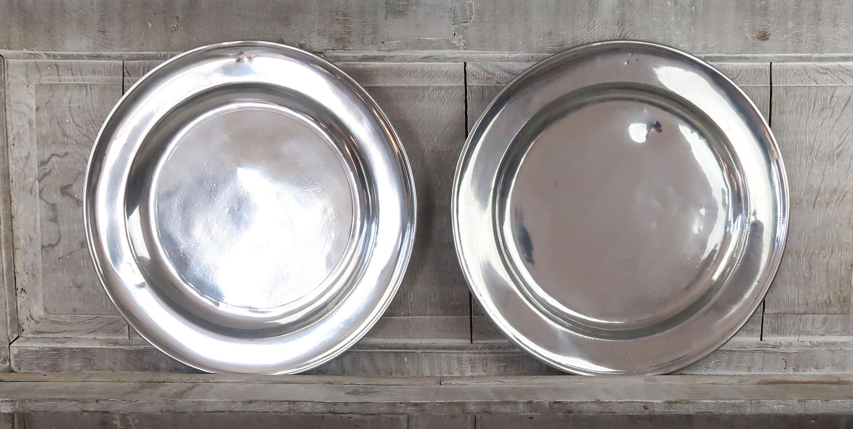 2 great highly polished pewter chargers. Measure: (18 inches).

English, late 18th century

The same ownership inscription on the front rim of both of them.

Rubbed touch marks on the underside. Probably a London maker.

The pewter has been