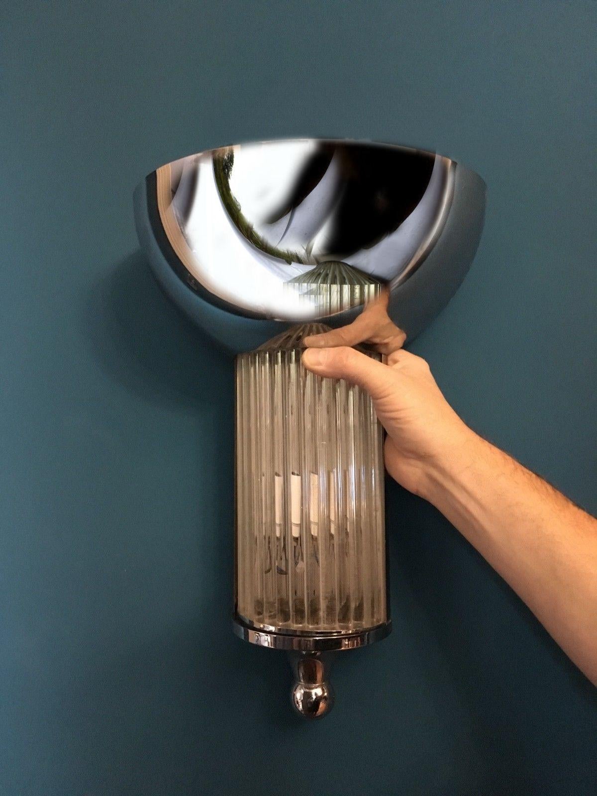 Lovely pair of large Cinema style Art Deco chrome and glass rods wall lights. Excellent used condition, each light takes two bulbs with a light behind glass rods and in chrome up-lighter shade. Wonderful ambient lighting makes these lights a real