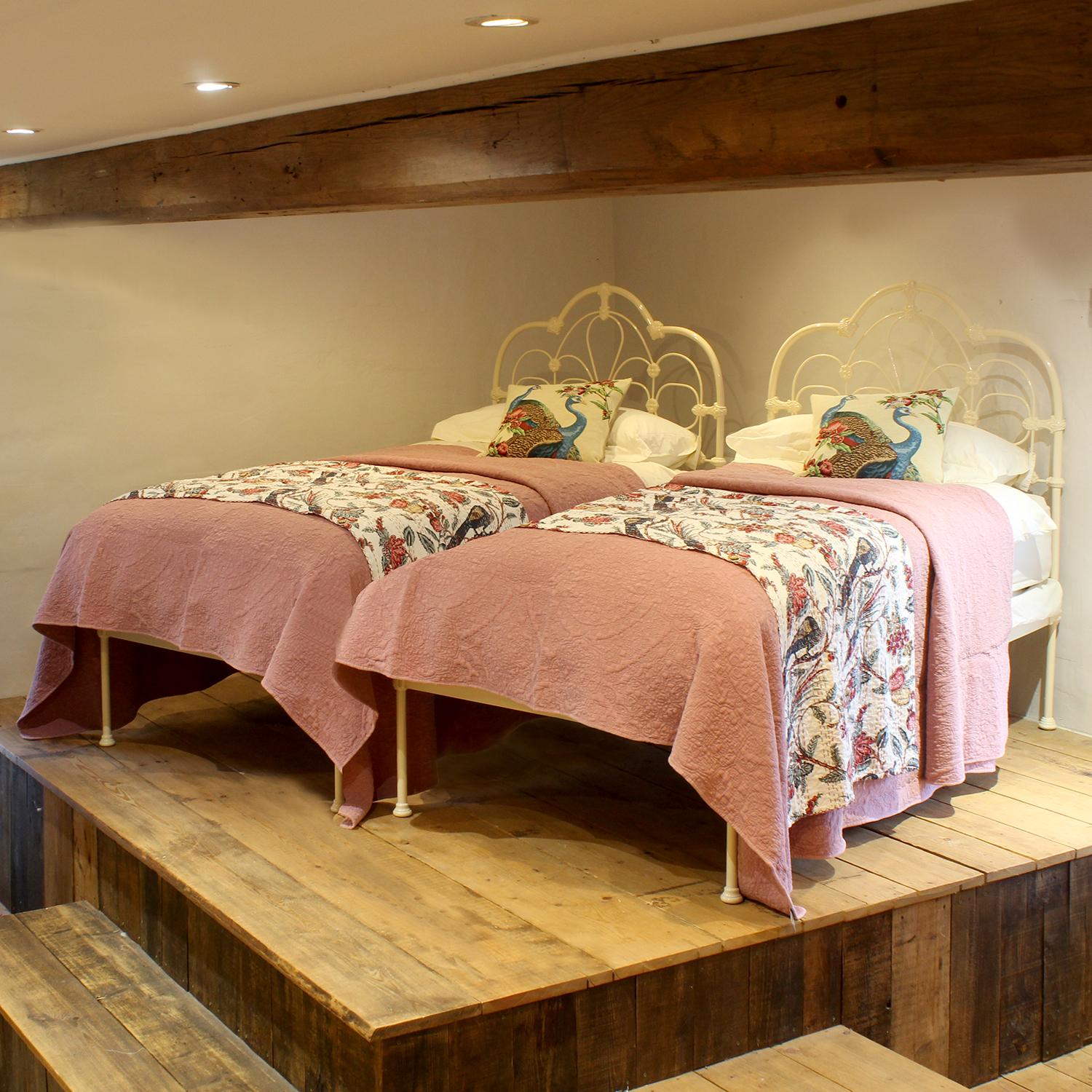 Ein passendes Paar antiker Betten aus Gusseisen mit verschnörkelten, gewölbten Rückenpaneelen, in Creme gehalten.
Diese Betten sind für Lattenroste und Matratzen mit einer Breite von 107 cm (42 Zoll) geeignet.
Die Betten können miteinander verbunden