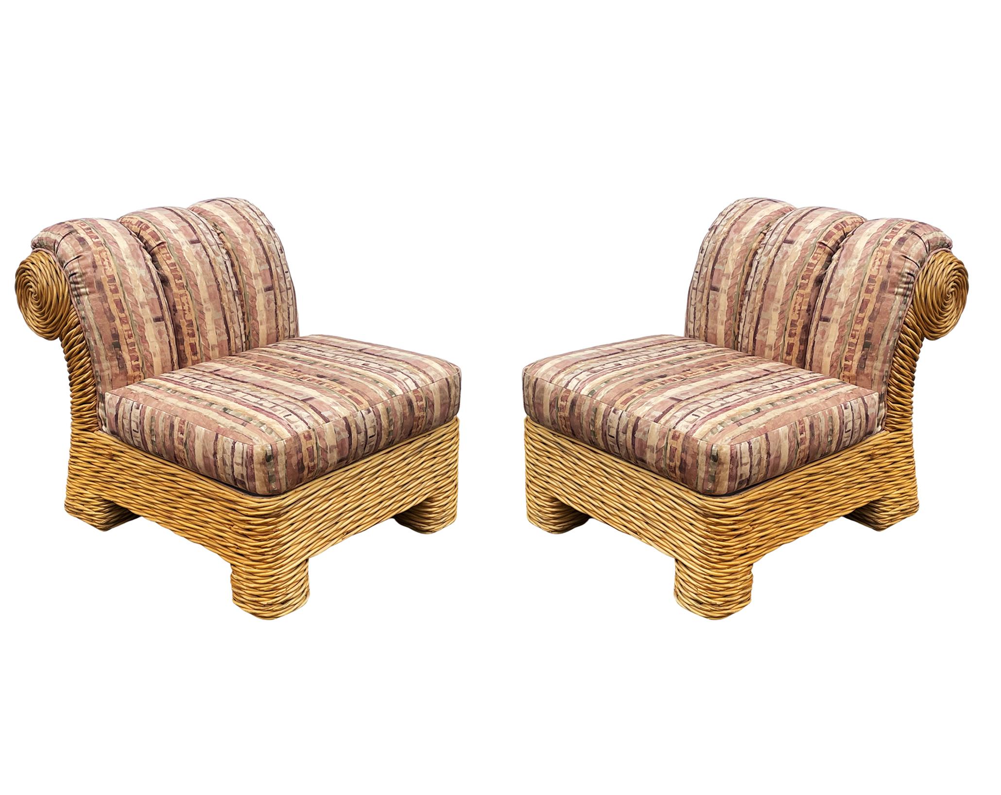 A pair of decorator slipper lounge chairs circa 1980's. These feature woven rattan frames with fabric seating area. Fabric is dated and could use an update. Heavy and very well made.