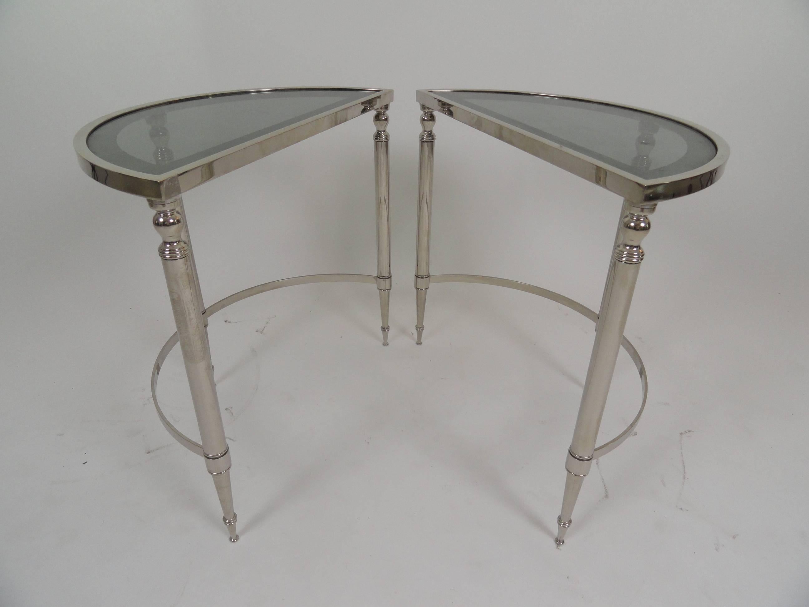 Pair of recently nickel-plated demilune tables with antiqued glass insert tops. Tables may be used together to form a round table or separately to make two half-circle tables. Nickel plating is recent and in very good condition.