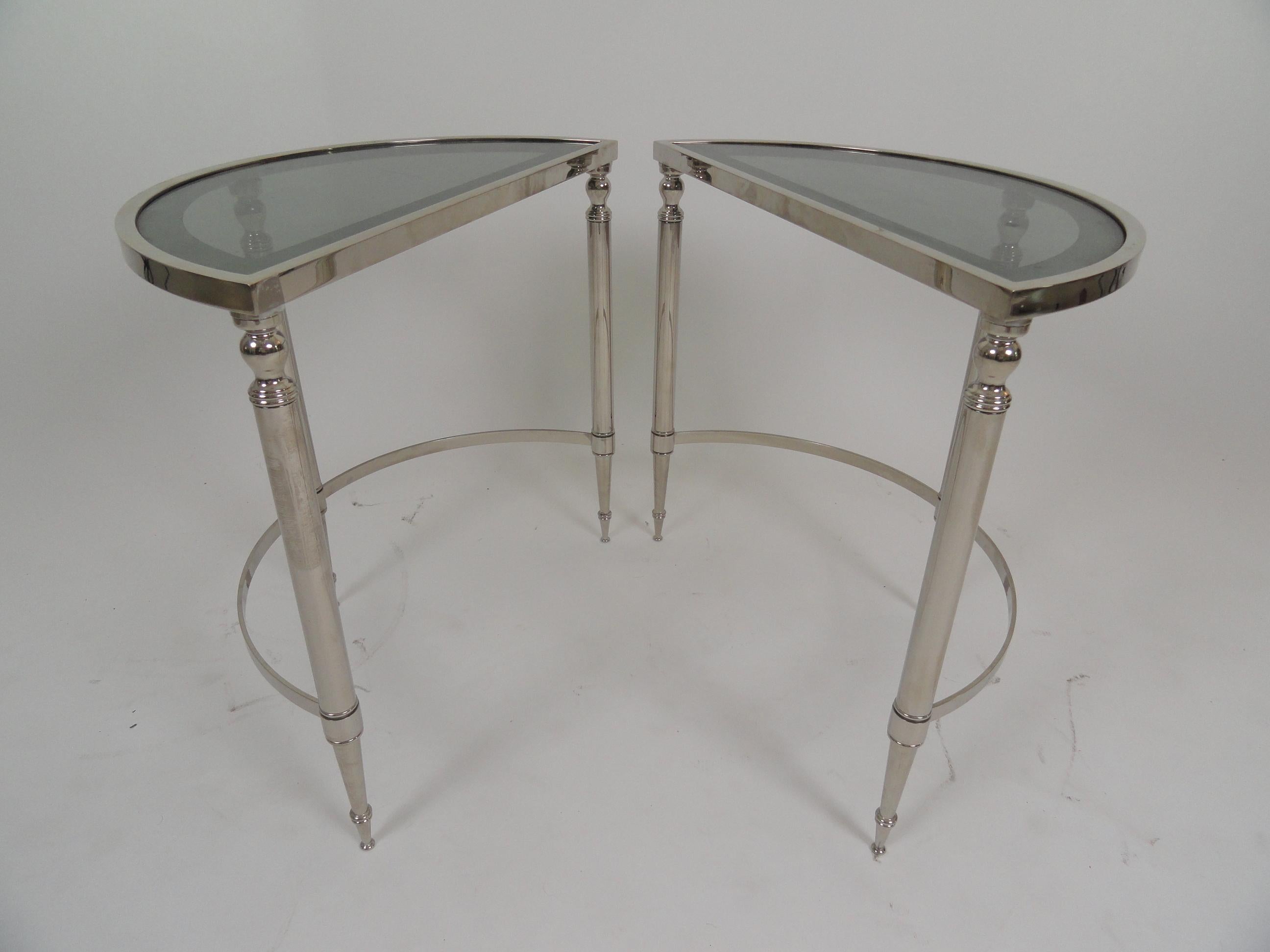 Pair of recently nickel-plated demilune tables with antiqued glass insert tops. Tables may be used together to form a round table or separately to make two half-circle tables. Nickel plating is recent and in very good condition.