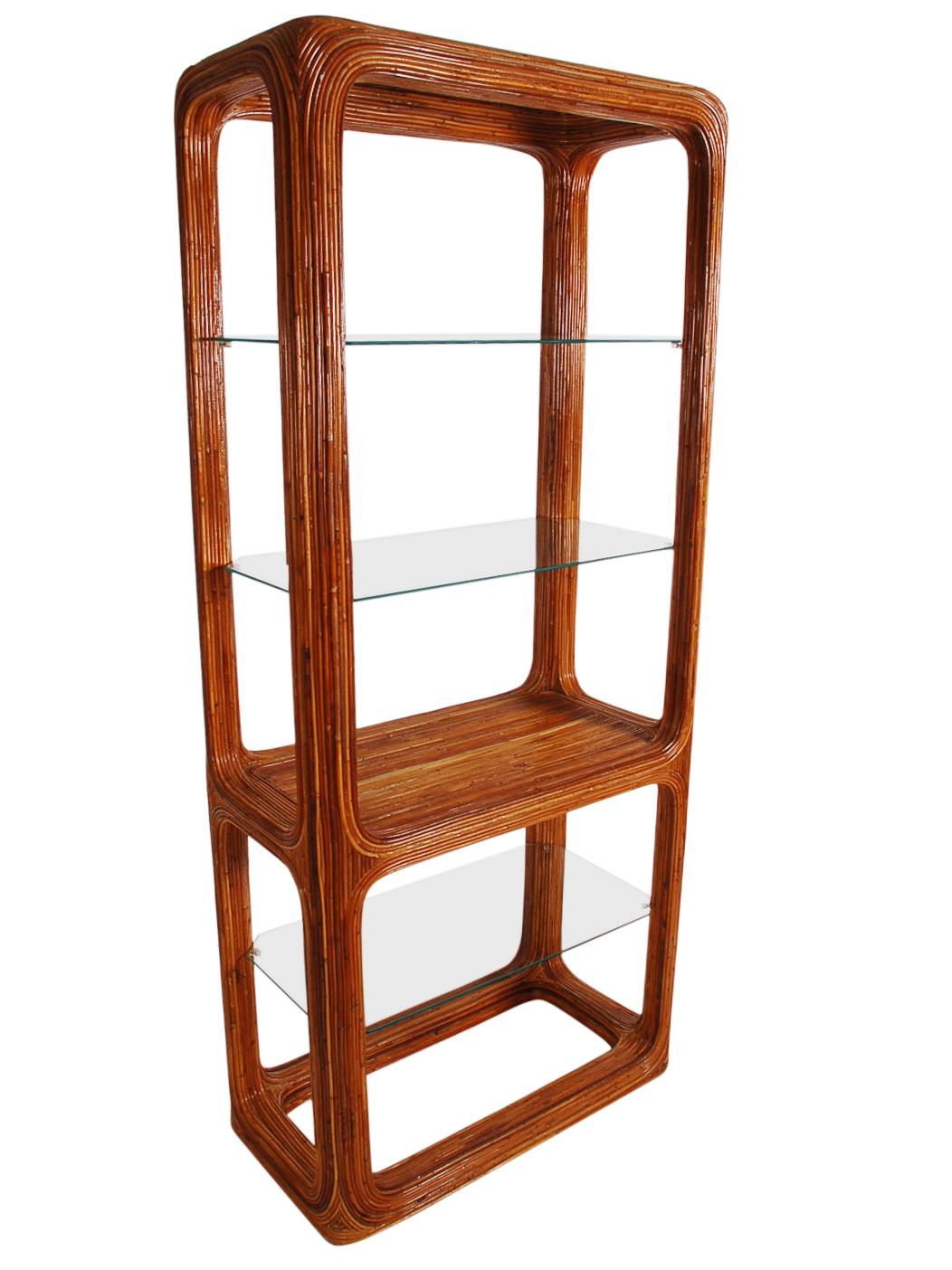 A sculptural matching pair of étagères. These feature wood and pencil reed frames with glass shelving. Well cared for through the years. Price includes the pair as shown.