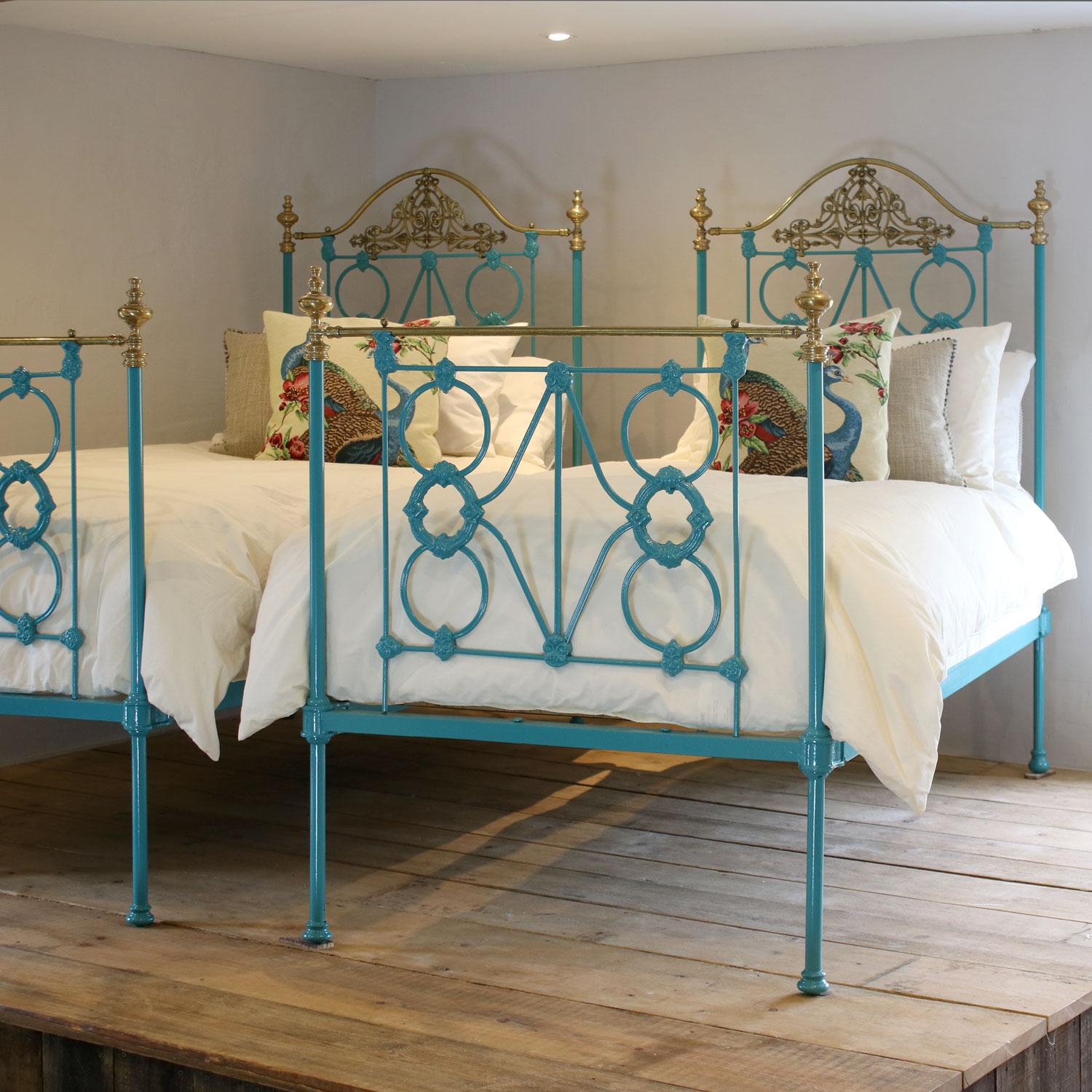 A matching pair of twin brass and iron antique beds with cast iron panels, ornate brass castings and serpentine brass top rails on the head ends, finished in striking turquoise blue.

These beds accept 3ft wide (36 inch or 90 cm) bases and