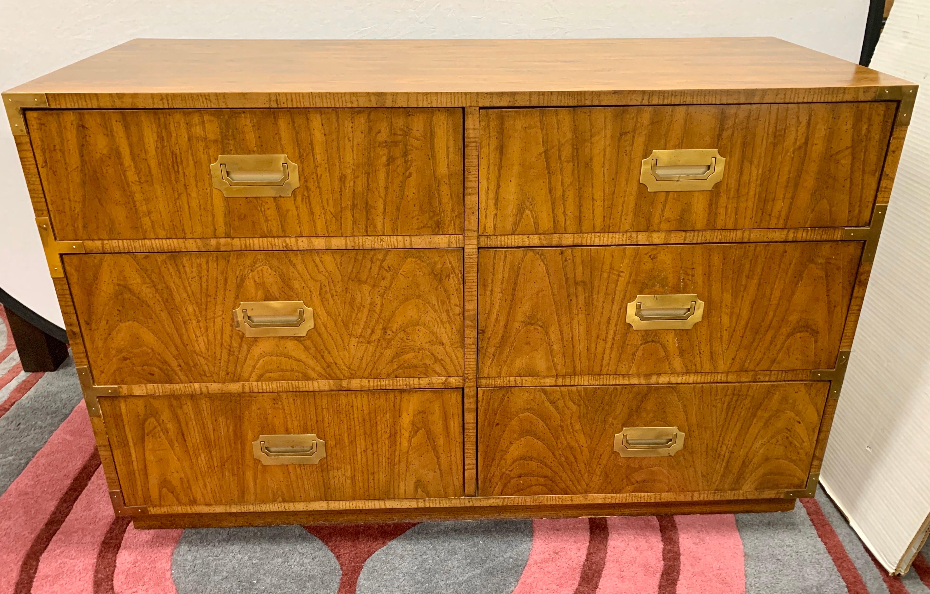 Pair of matching vintage campaign style dressers with original recessed brass pulls and hardware. Six fully functioning dovetailed drawers glide smoothly on center tracks on each piece. Marked Dixie and Campaigner inside top drawer.