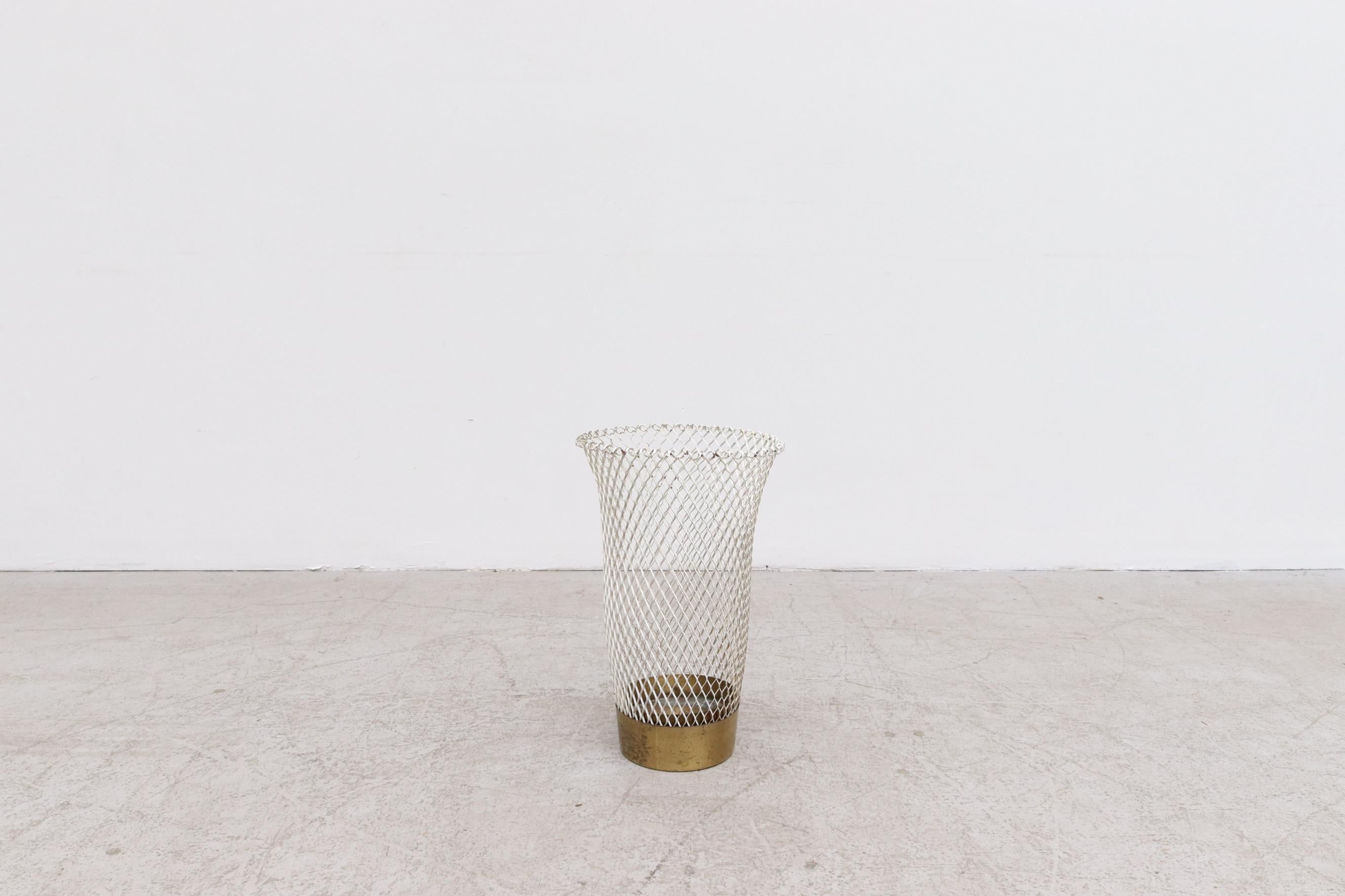 Mid-Century Mathieu Mategot inspired woven metal waste bin or umbrella stand with brass frame. In original condition with visible signs of wear consistent with its age and use, including paint loss and tarnishing of brass. May include some denting,