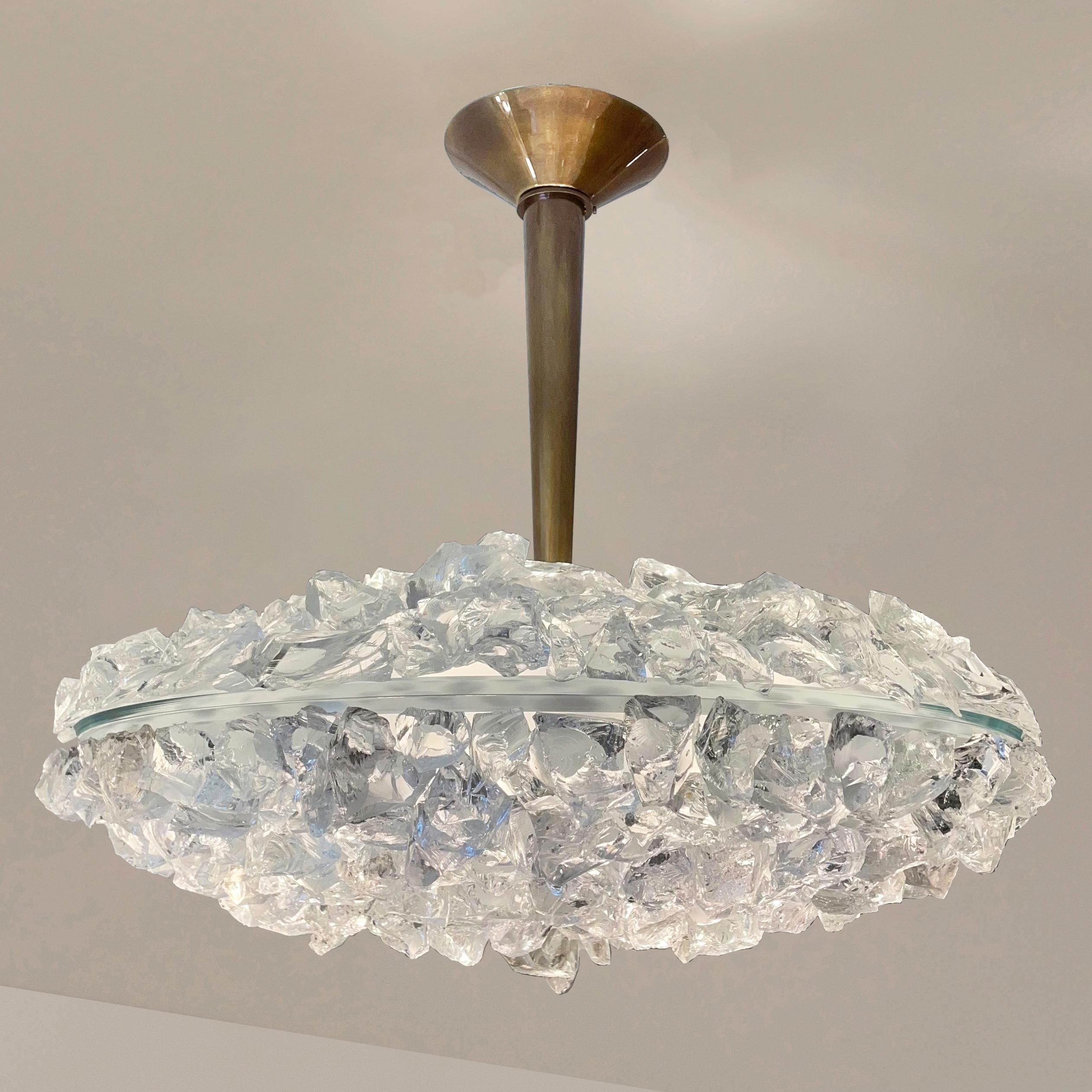 The focal point of the Matera Grande ceiling light is the sculptural glass shade composed of dozens of hand applied crystal elements. Its clean and modern stem and canopy, create a balanced contrast to the organic feel of the rest of the piece. Can