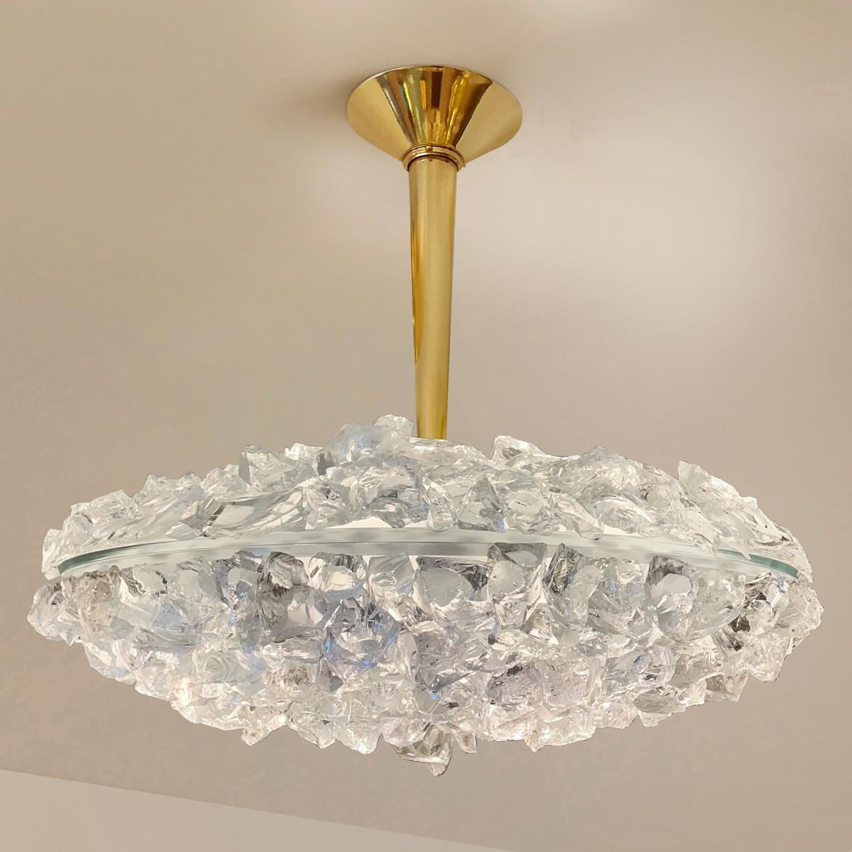 The focal point of the Matera Grande ceiling light is the sculptural glass shade composed of dozens of hand applied crystal elements. Its clean and modern stem and canopy, create a balanced contrast to the organic feel of the rest of the piece. Can