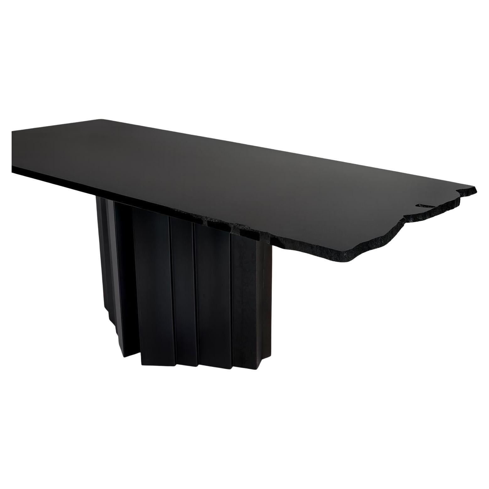 La table Materico est un assemblage architectural unique qui combine les formes contrastées d'une base géométrique audacieuse avec le détail naturel de son plateau à bord brut. 
Visuellement, cette table audacieuse présente un impact monolithique