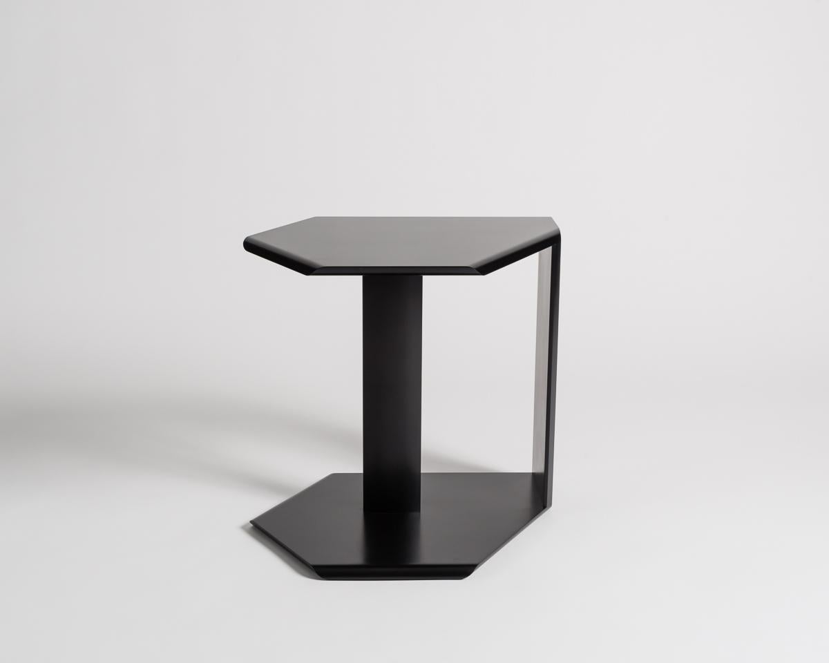 Each of these black, geometric side tables features a high finish, two stanchions, and impeccably smooth, beveled edges. Two versions (parallel over a vertical plane) can be made.