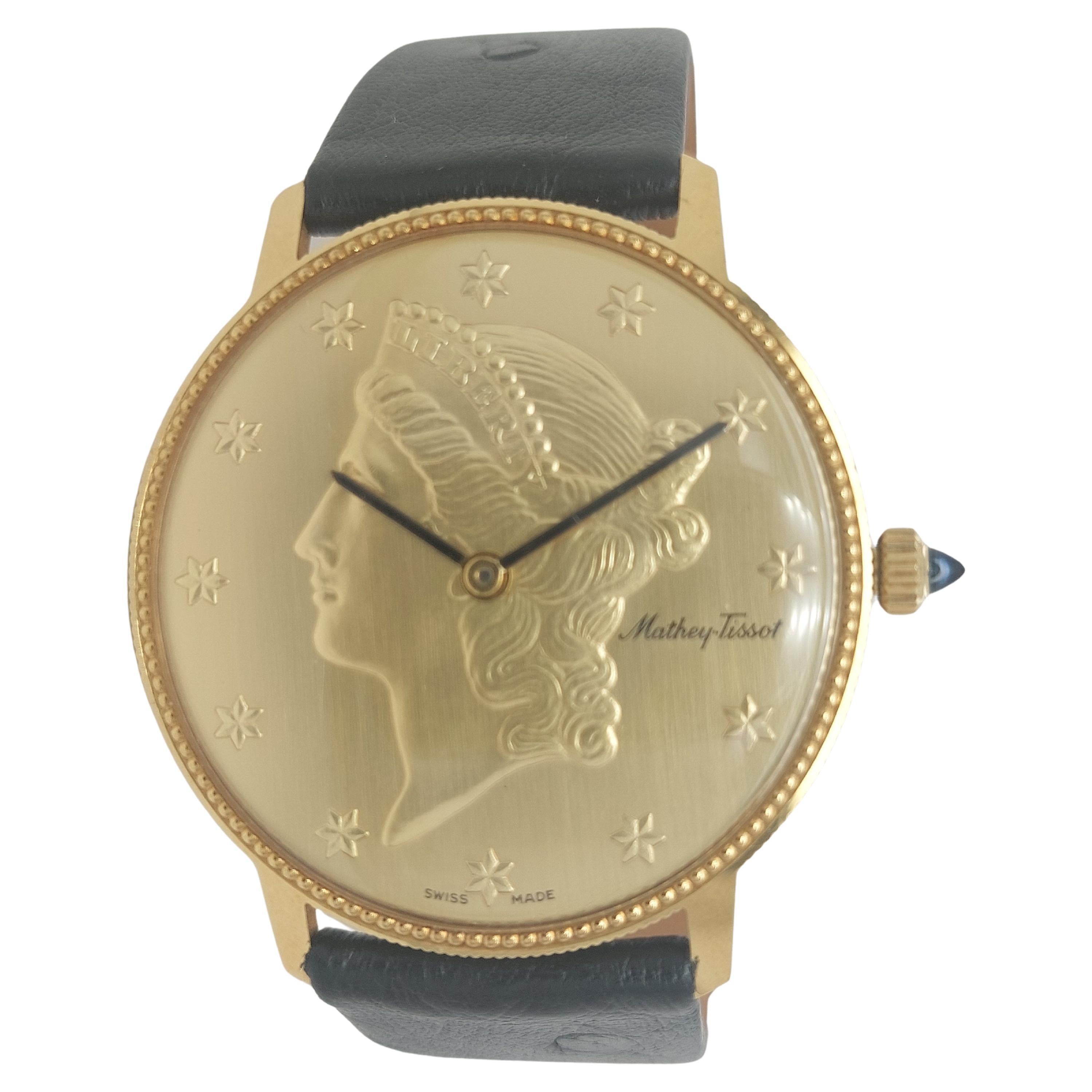 Mathey Tissot 18 kt Gold Liberty Coin Watch, Mechanical Movement, With Box

Functions: Hours, Minutes

Movement: Mechanical Movement, Hand winding

Dial: Gold dial with stars as numerals and black indexes.

Case: 18kt yellow gold round case,