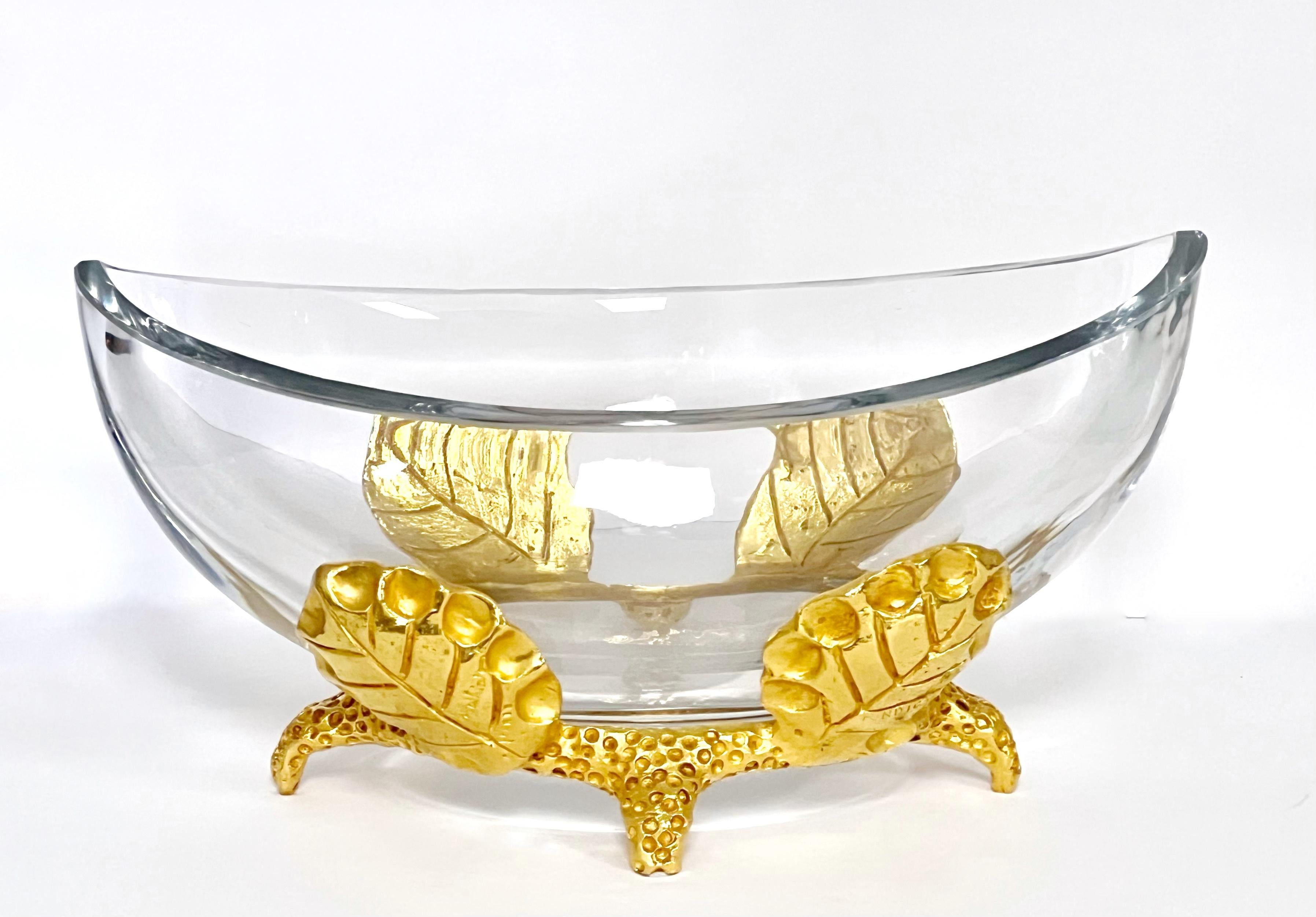 Un pesante centrotavola in bronzo e cristallo di Mathias for Fondica. 
La base è in bronzo dorato ed è realizzata nel classico stile Fondica, con un design audace e stilizzato di ispirazione neo-barocca. 