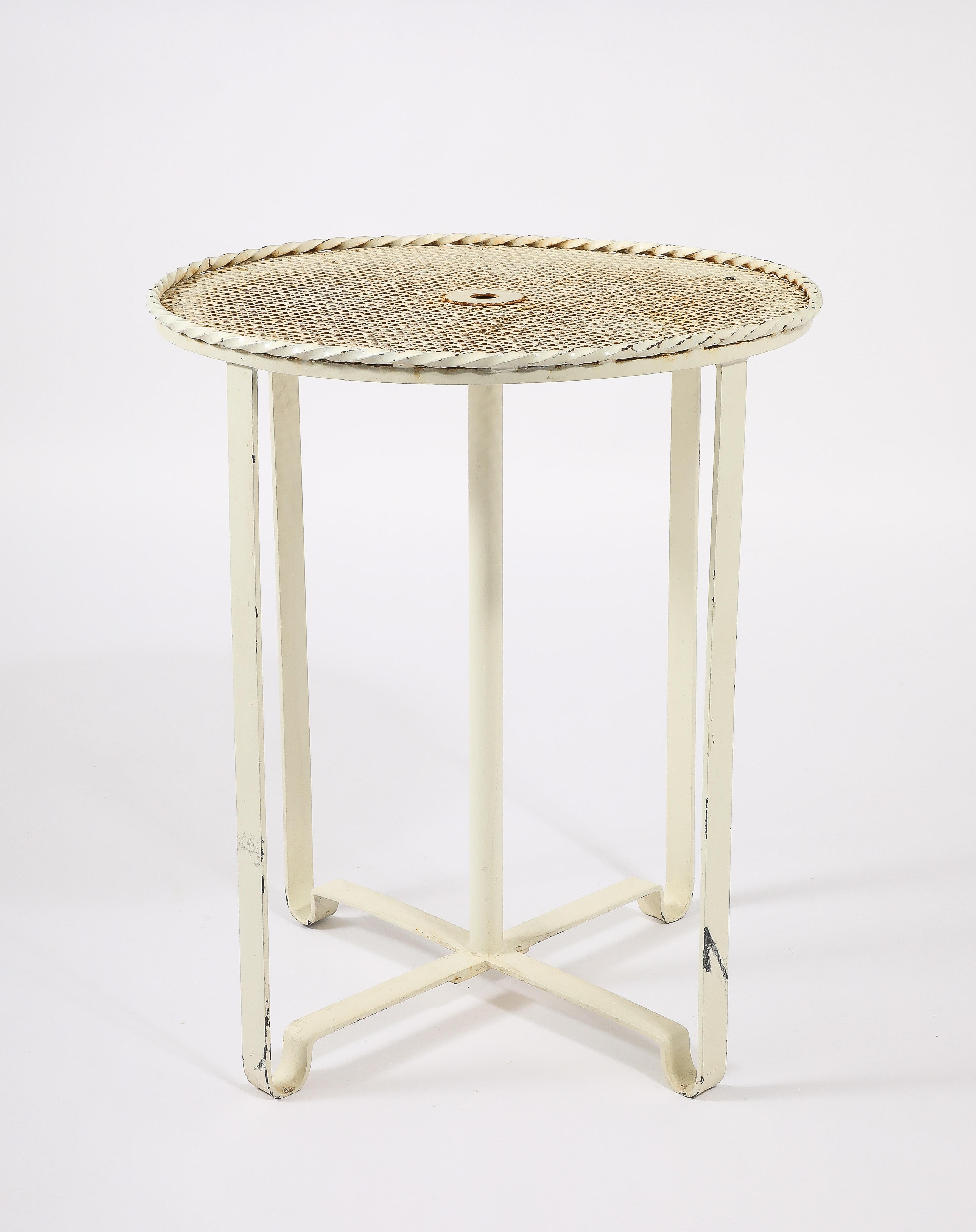 Piédestal en fer forgé avec un poteau central (pour un parapluie), un dessus percé et un mouvement intéressant des pieds. Trois de ces tables sont disponibles, vendues à l'unité.