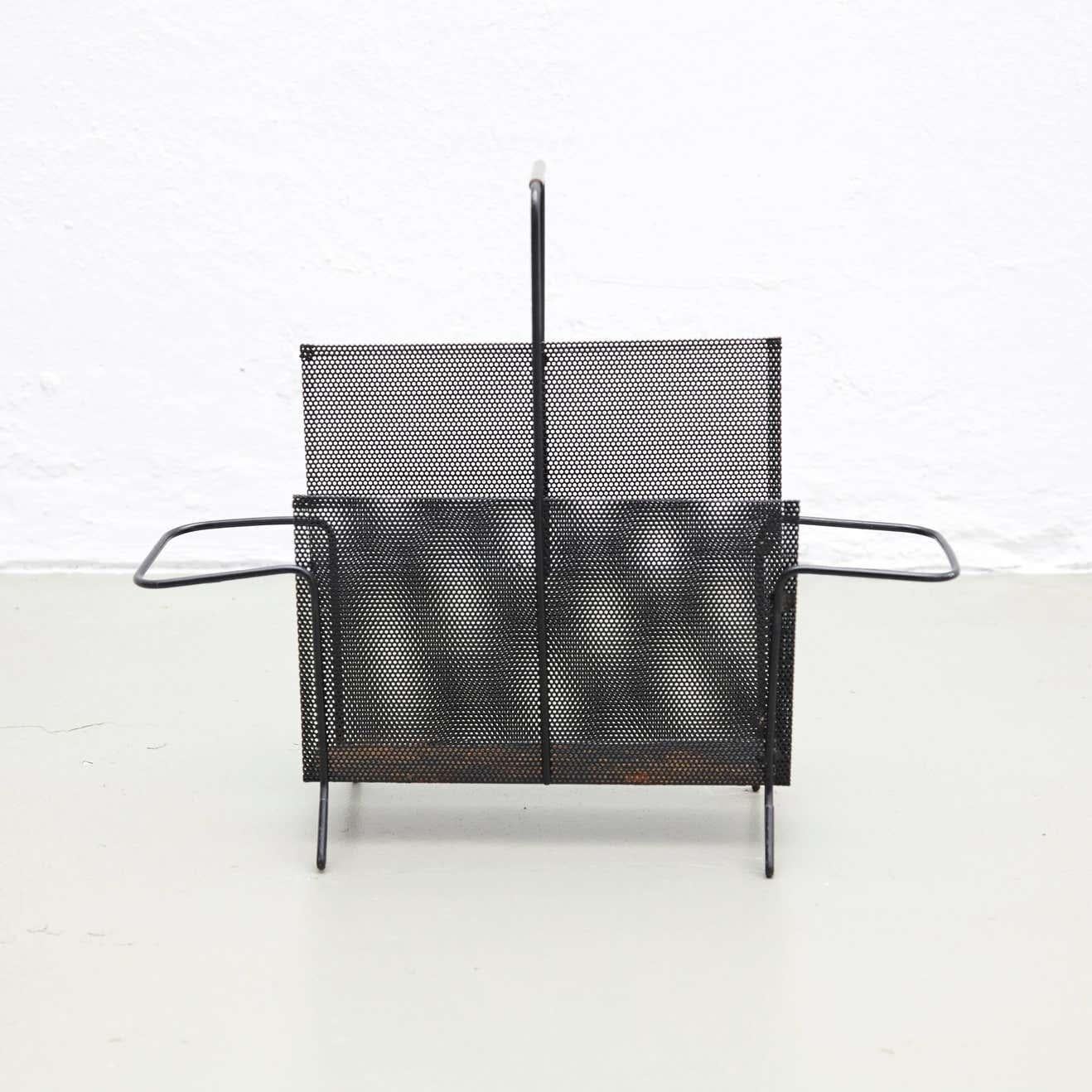 Magazine holder, designed by Mathieu Matégot.
Manufactured by ateliers Matégot (France), circa 1950.
Folded, perforated metal.

In good original condition, with minor wear consistent with age and use, preserving a beautiful patina. With some