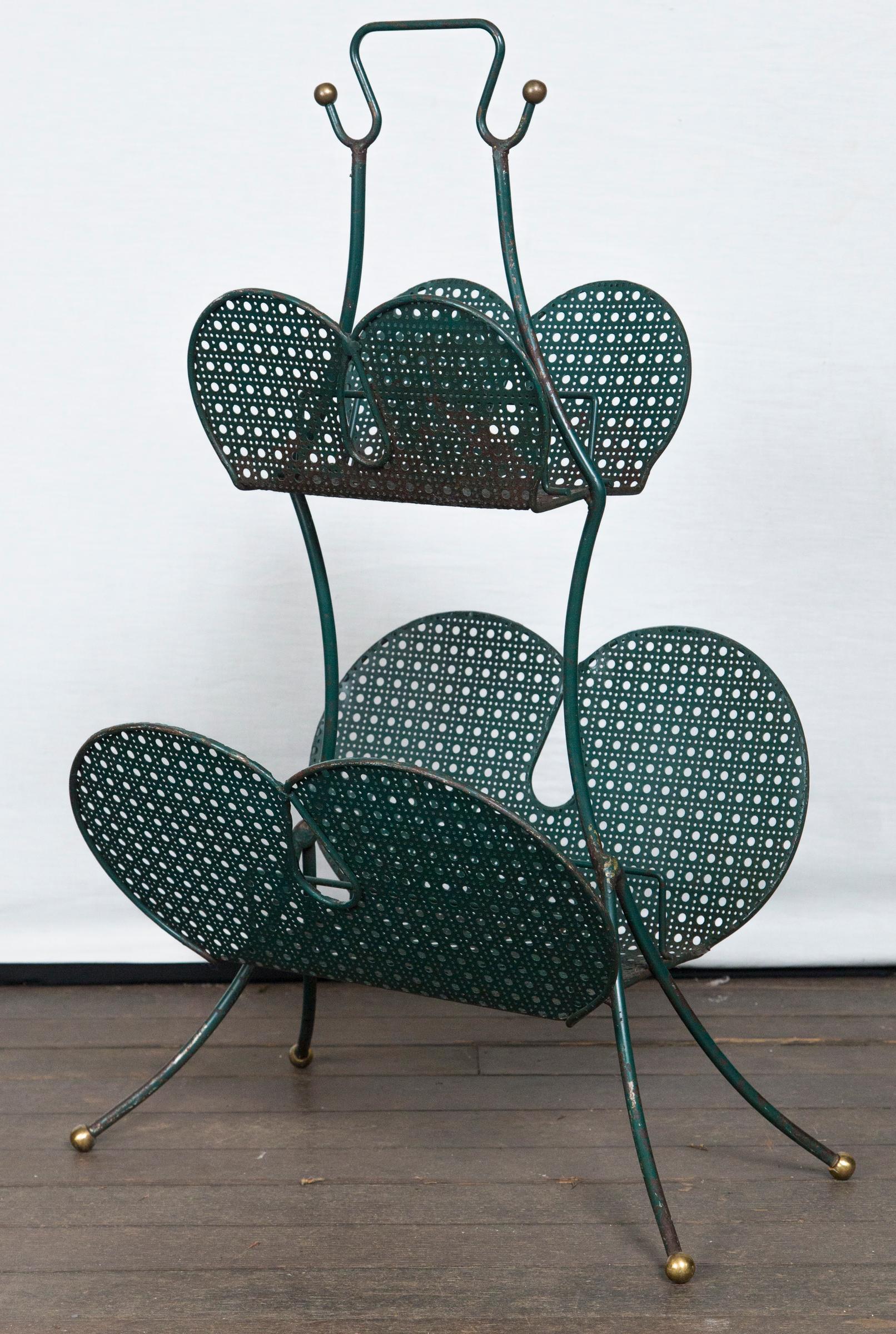 A French Matégot metal magazine rack which is both modern and whimsical from the 1950, perforated metal, metal, and brass.