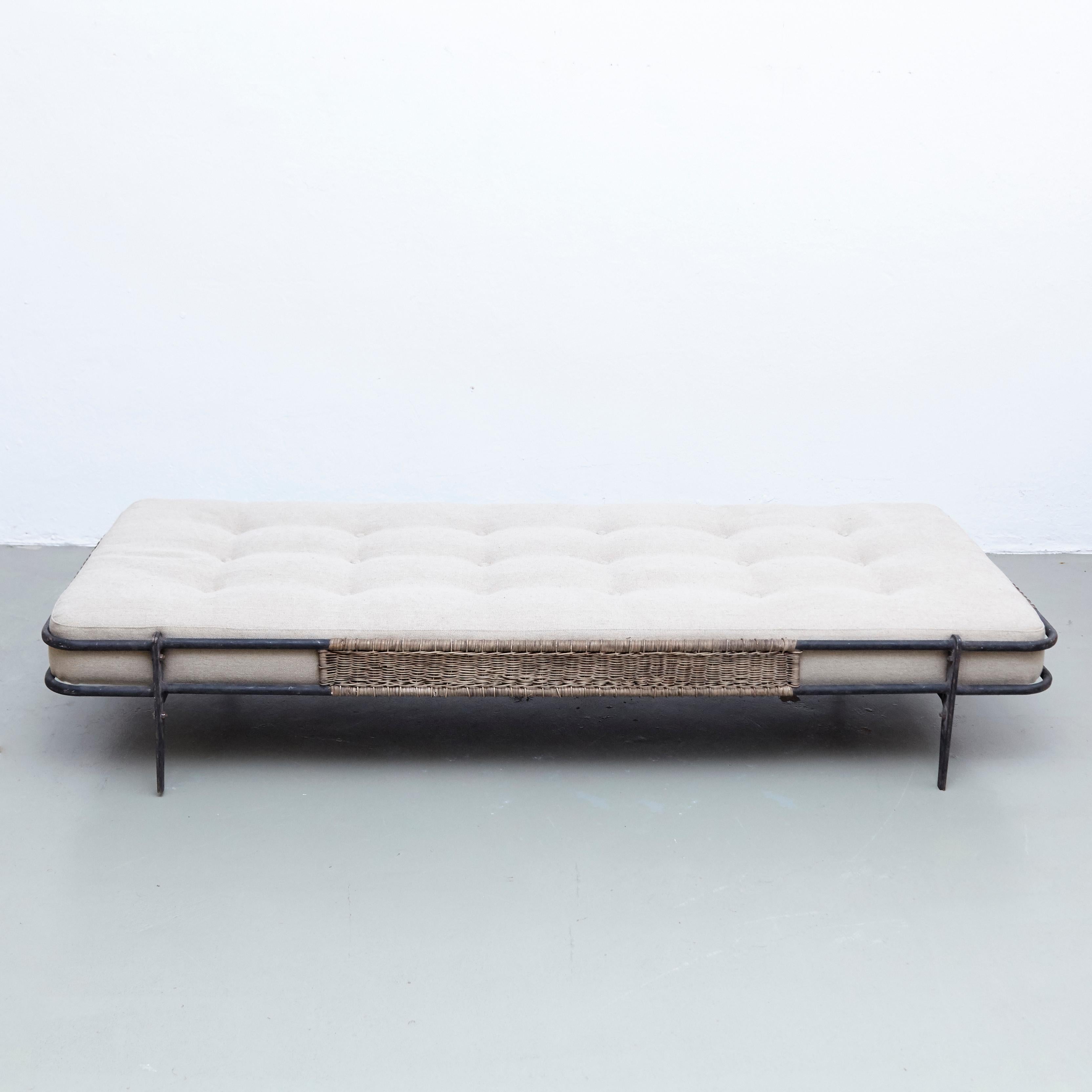 Daybed designed by Mathieu Matégot.
Manufactured in France by Ateliers Matégot, circa 1955.

Bed in metal with rattan on the sides.

In good original condition, with minor wear consistent with age and use, preserving a beautiful