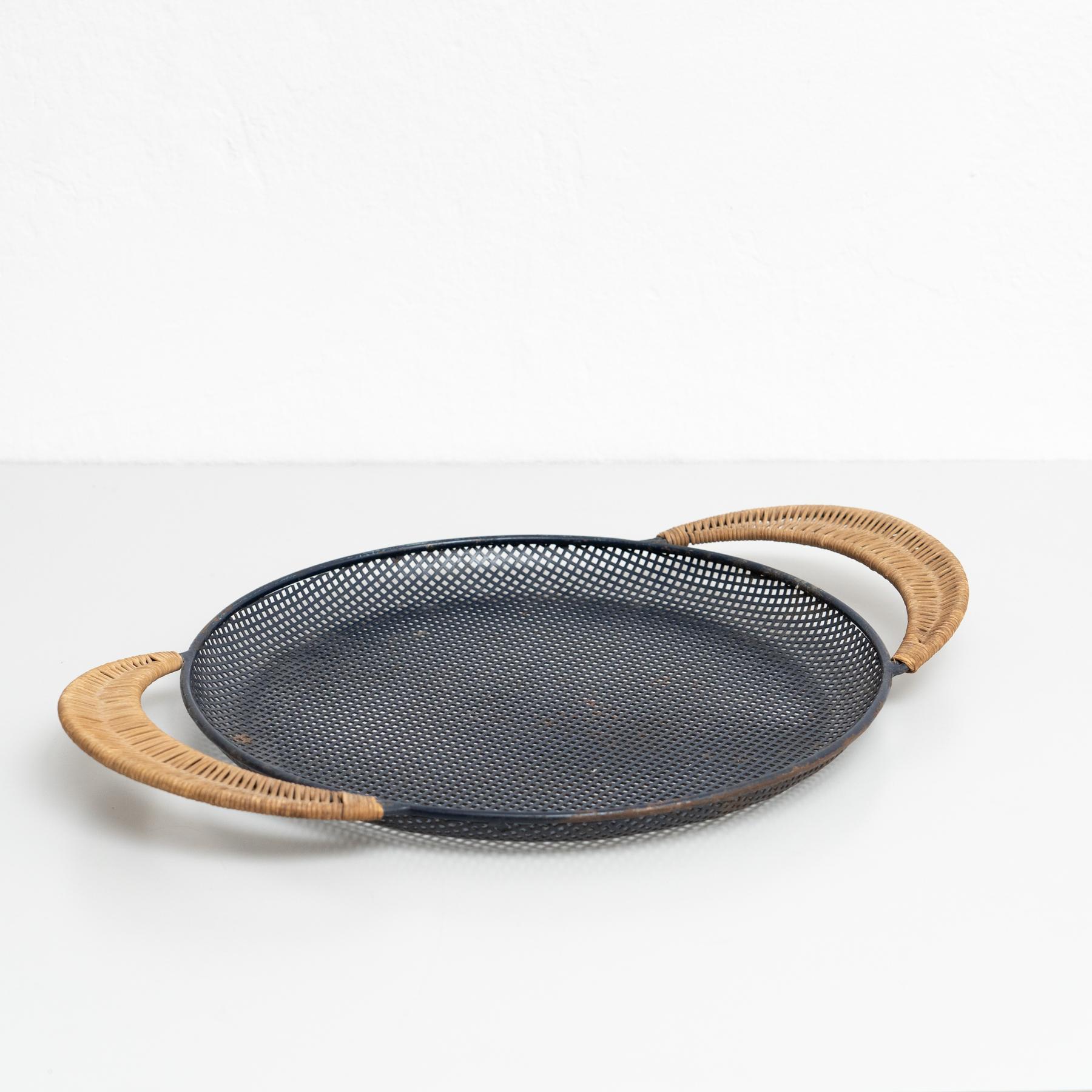 Bandeja de metal esmaltado diseñada por Mathieu Matégot.
Fabricado por Ateliers Matégot (Francia), hacia 1950.
Azul oscuro - Negro Metal perforado lacado con pintura original y detalles de ratán.

En buen estado original, con pequeños desgastes