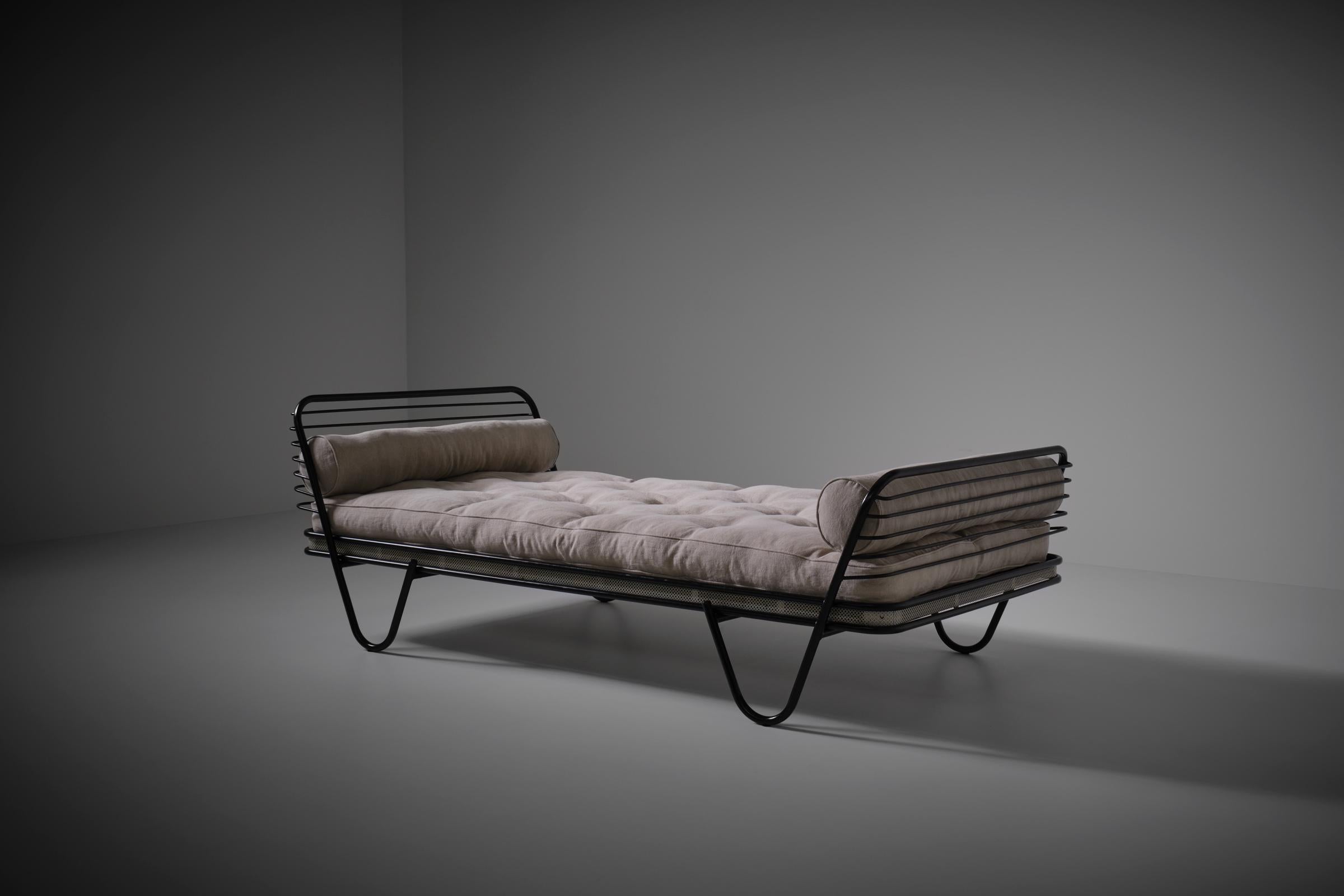 Mathieu Matégot 'Kyoto' daybed, France 1950s. Striking design out of a black lacquered metal tubular frame and and white perforated metal lining. Beautiful play of horizontal lines and architectural column shaped feet which flow over in the side