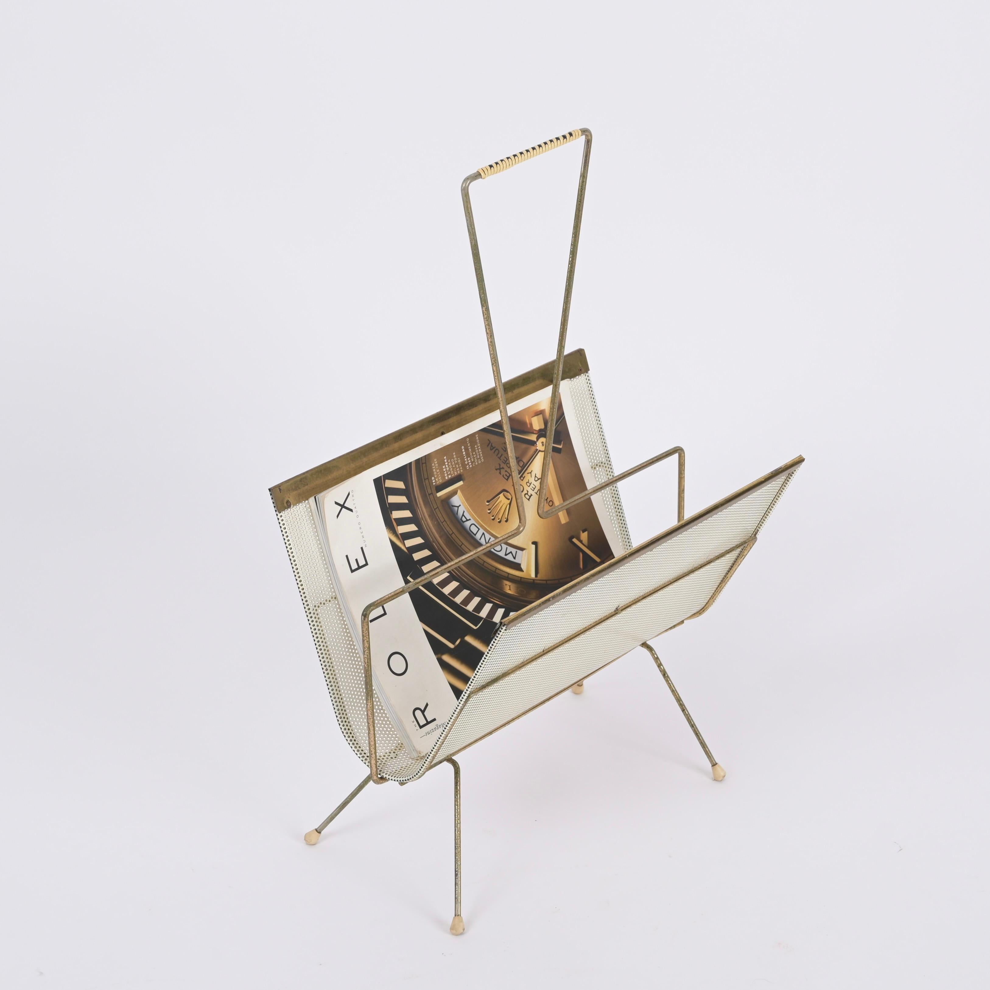 Gorgeous magazine rack in brass and enameled and perforated metal. This stunning piece was realized in France during the 1950s by Mathieu Mategot.

This one of a kind magazine rack has structure in gilt and bent iron that supports a rounded tray for