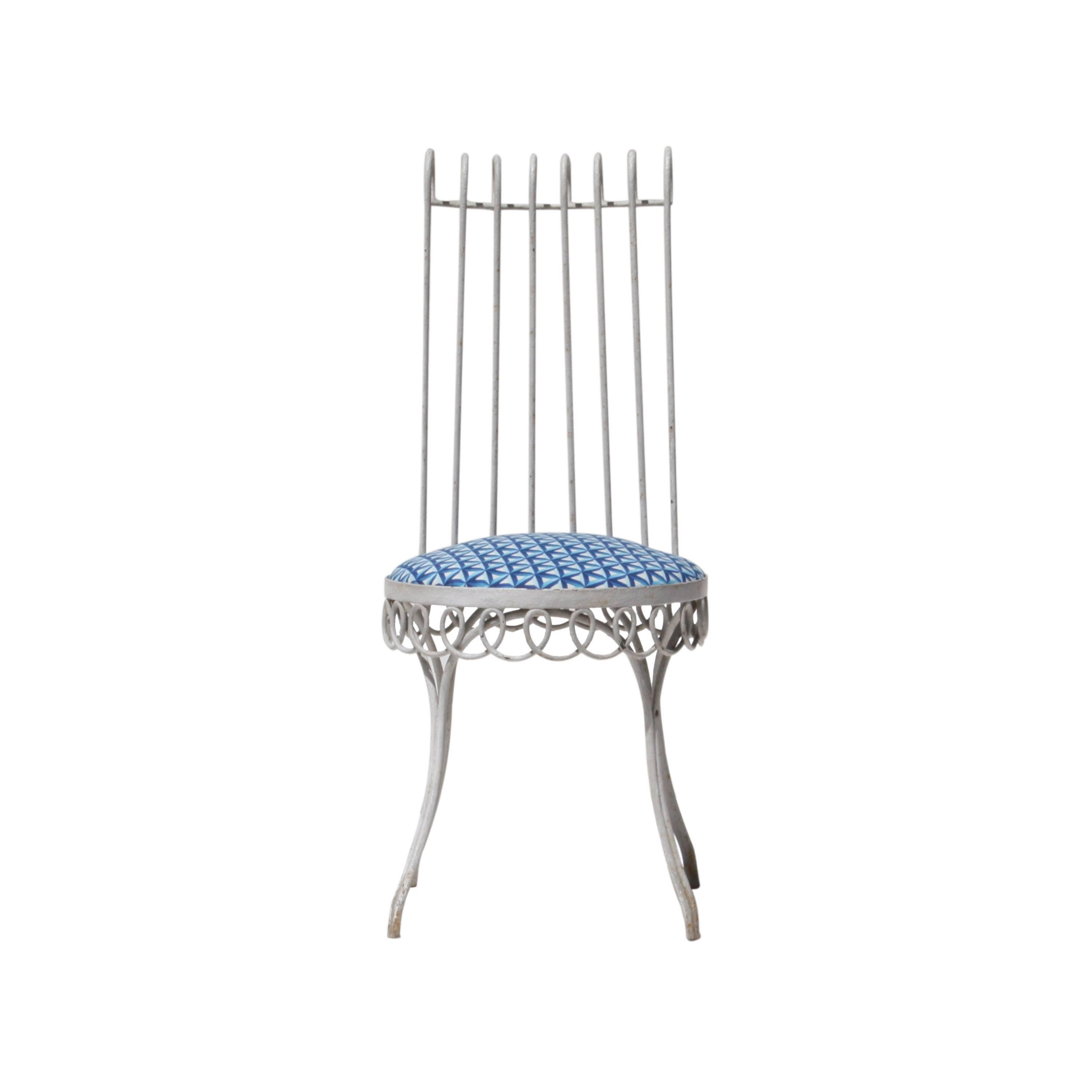 Ensemble de quatre chaises conçues par Mathieu Matégot. Structure en forge laquée blanche et assise restaurée avec revêtement en tissu de coton géométrique bleu.