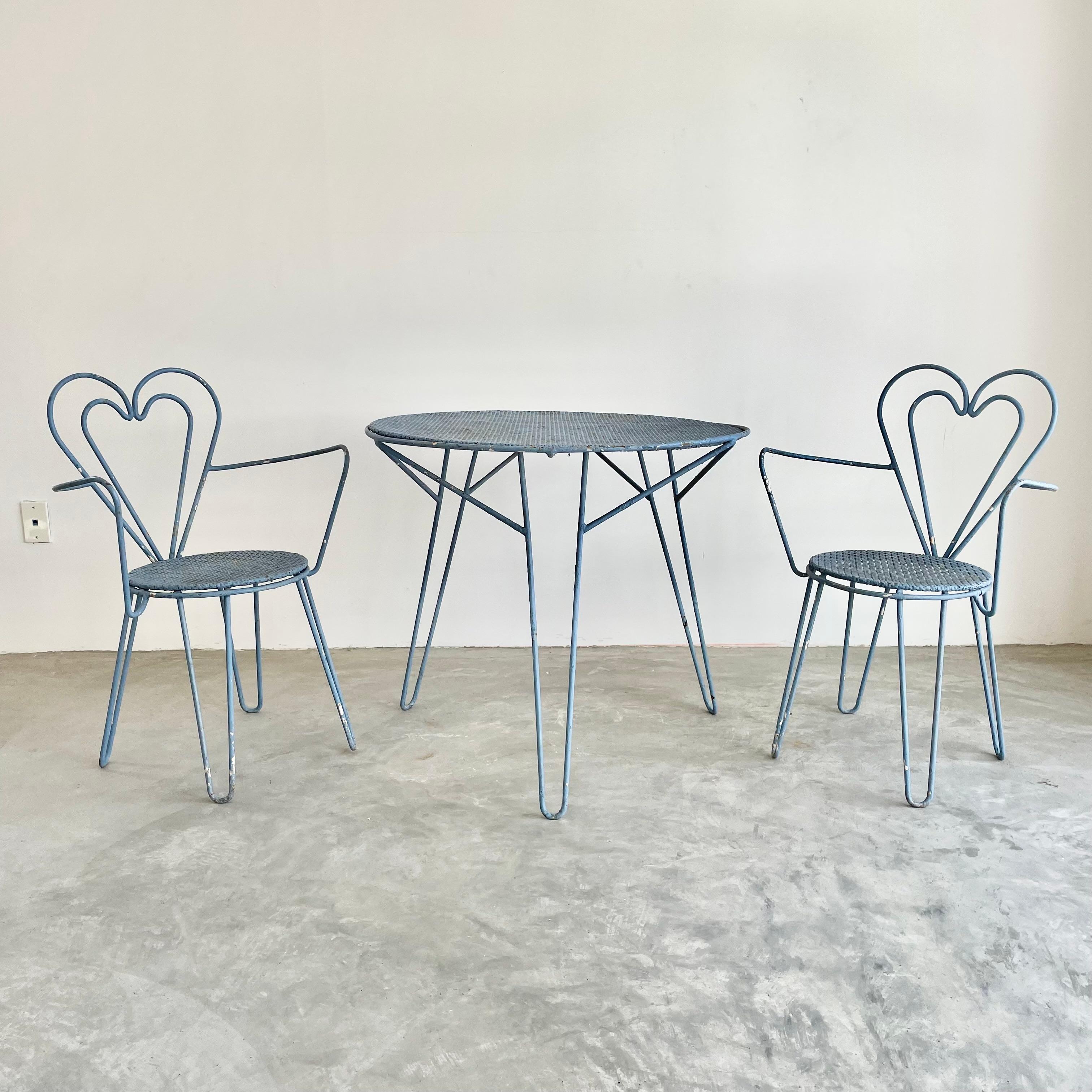 Rare metal dining set by French designer Mathieu Matégot. Entire set is in a stunning pastel blue. Sturdy metal chairs and table all with hairpin legs with signature Mategot perforated metal seats and table top. Chairs feature a beautiful heart