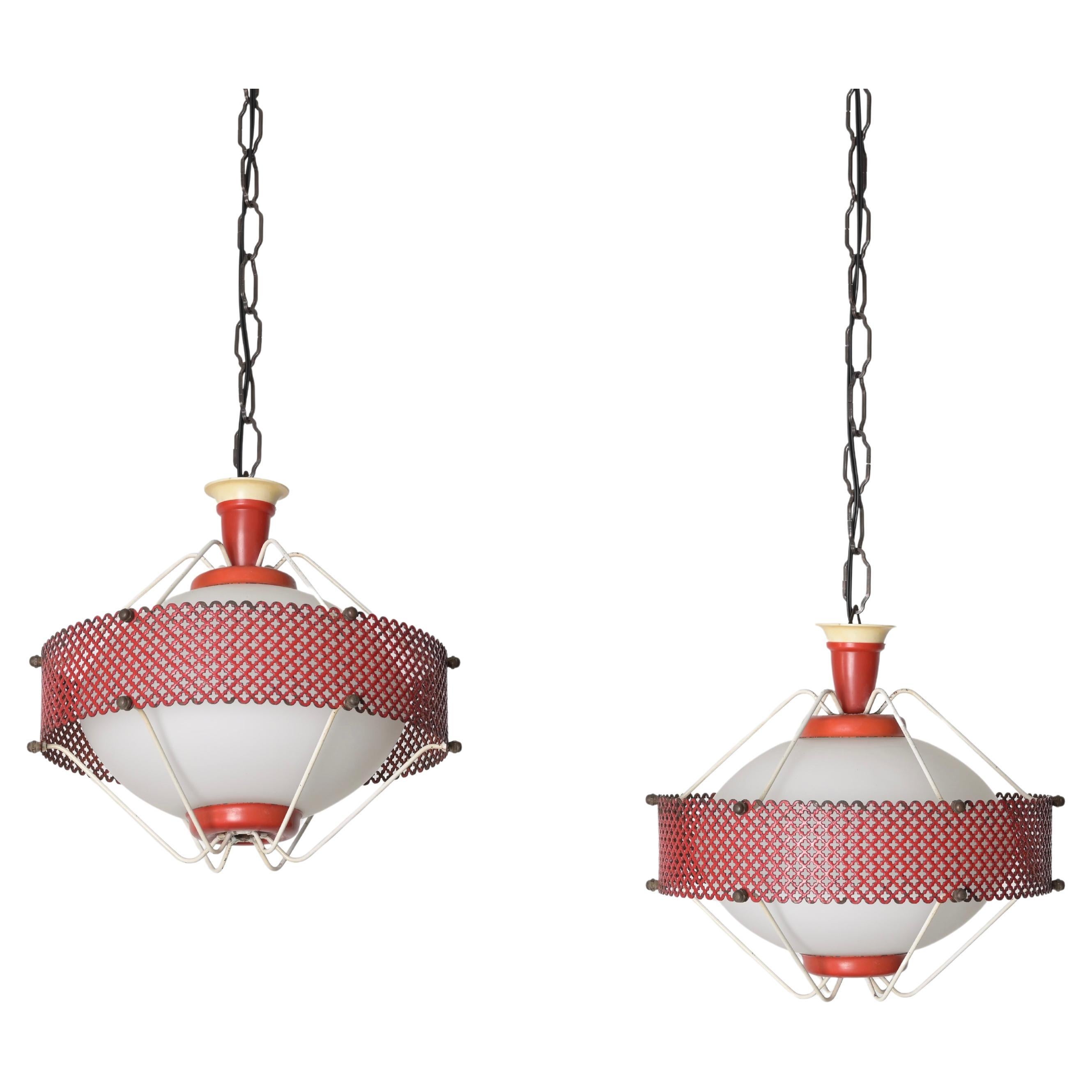 Delightful Mid-Century pendant lamps in opaline glass, red enamelled perforated metal and brass. This incredibly elegant and unique pendants were designed by Mathieu Matégot in France during the 1950s.

The round lines are the protagonists of this