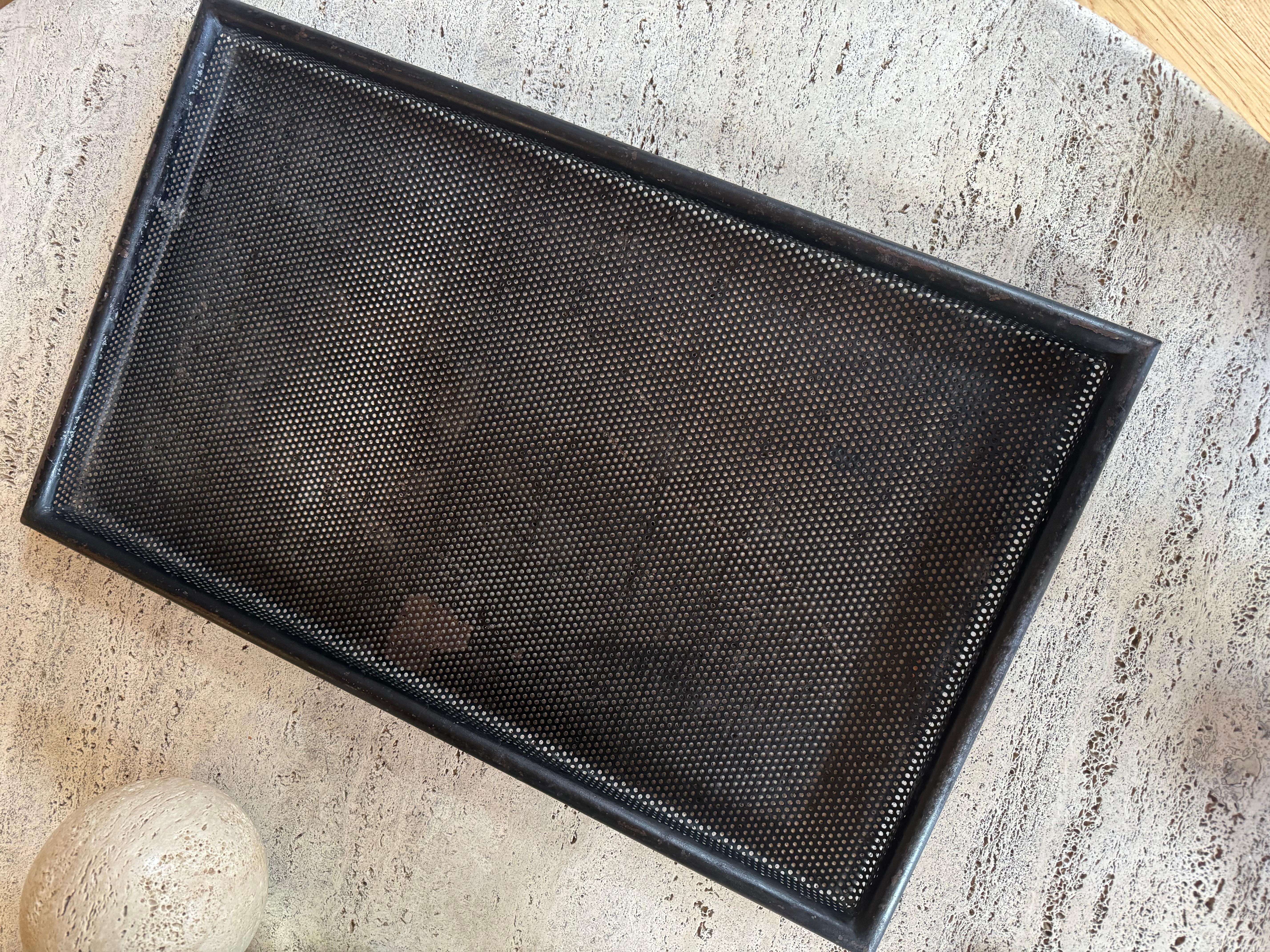 A large black pierced metal tray by Mathieu Mategot. Some paint loss and minor rust marks.