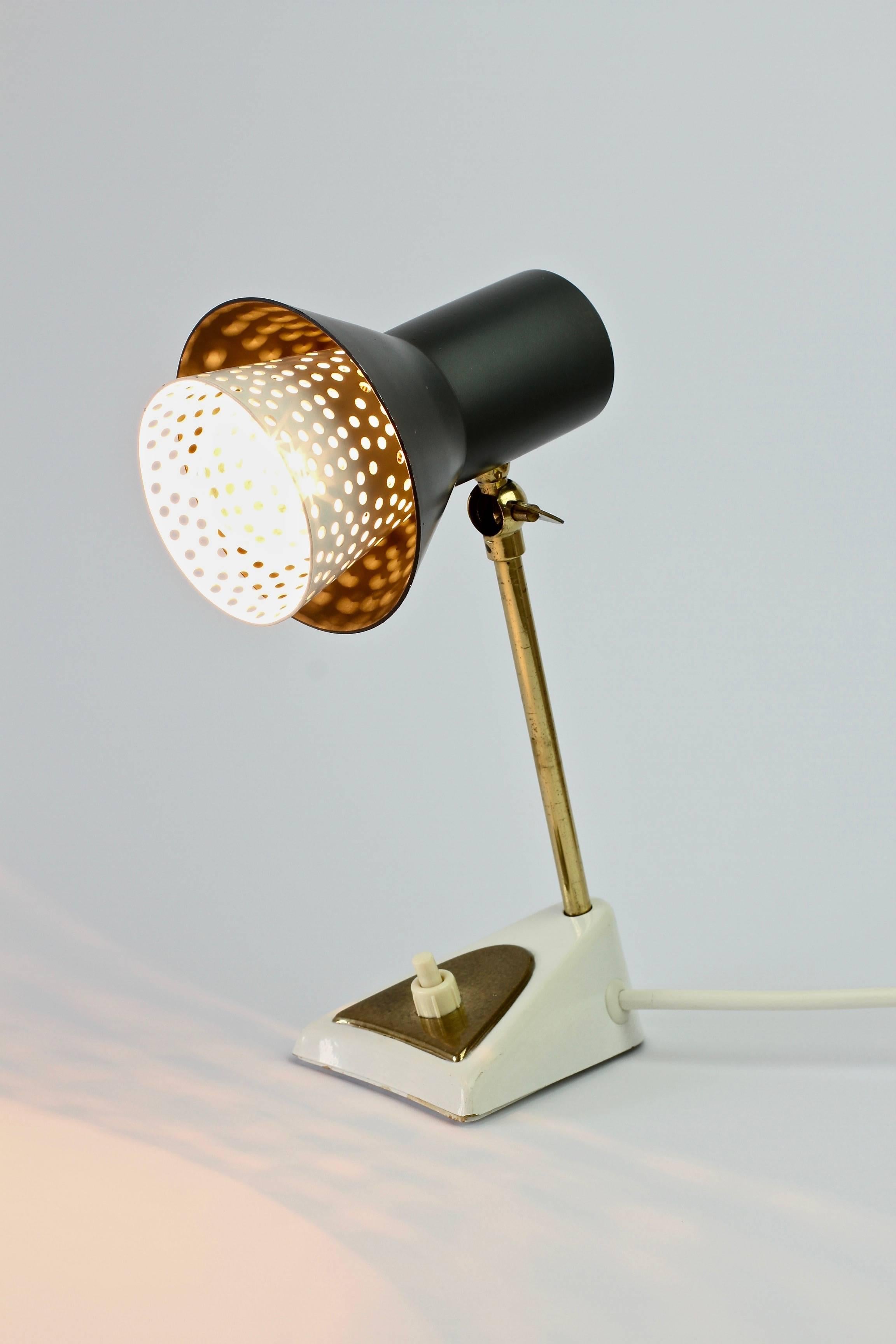 Vintage midcentury Modernist table or desk lamp in the style of Mathieu Matégot, circa 1950s-1960s. The perforated white metal inner shade is also similar to German designer Ernst Igl's lights for Hillebrand Leuchten. 

The lamp requires a single