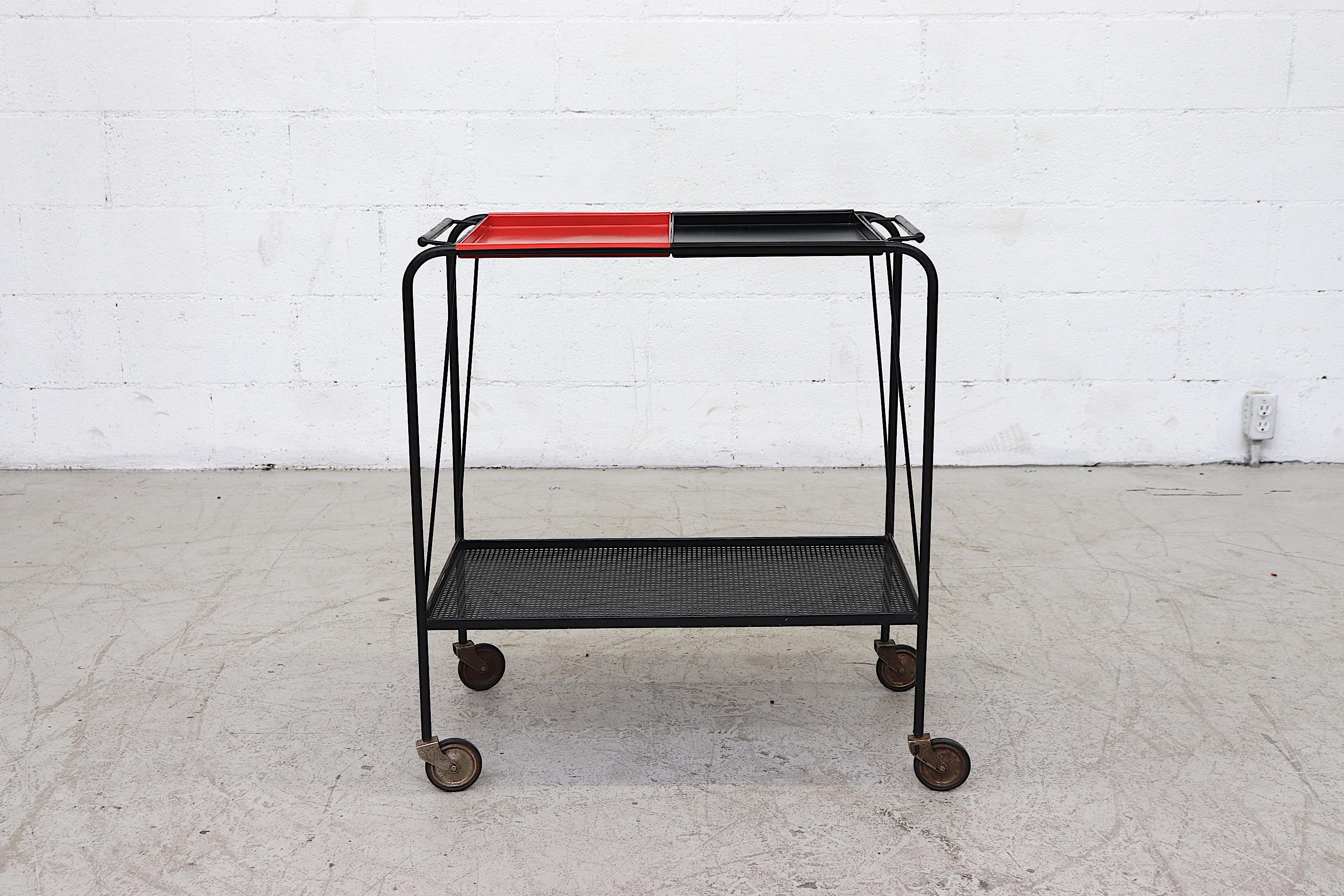 Handsome industrial bar cart by Tjerk Reijenga, for Pilastro. Black enameled frame and perforated metal lower shelf with newly powder coated black and red enameled removable metal trays. Beautiful and delicate lines. Frame in original condition with
