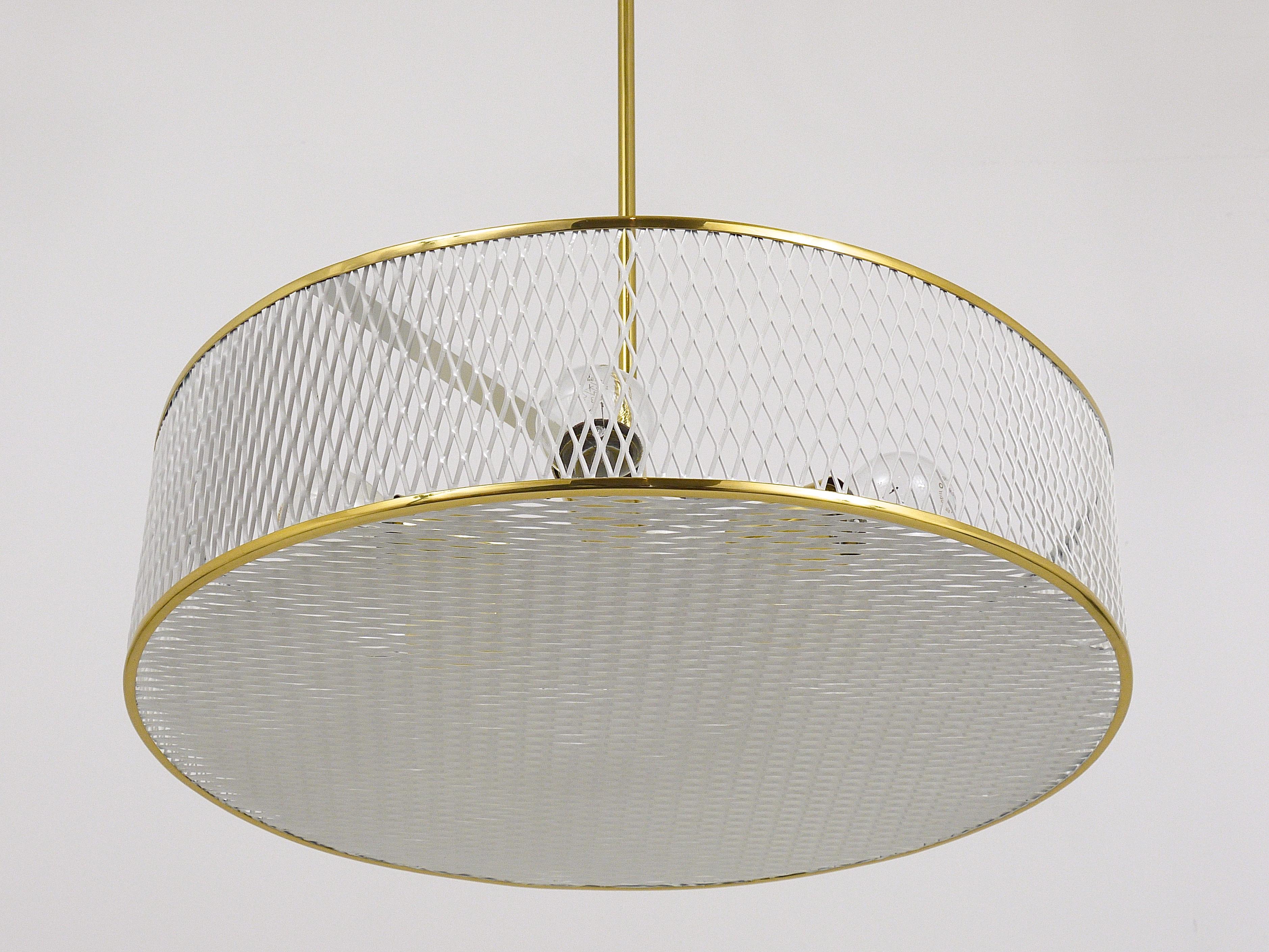 Bellissimo lampadario modernista in ottone e metallo traforato bianco, Francia, anni '50. Nello stile di Mathieu Mategot. È stata restaurata professionalmente ed è in condizioni eccellenti. Il lampadario è dotato di 6 lampadine e produce una luce