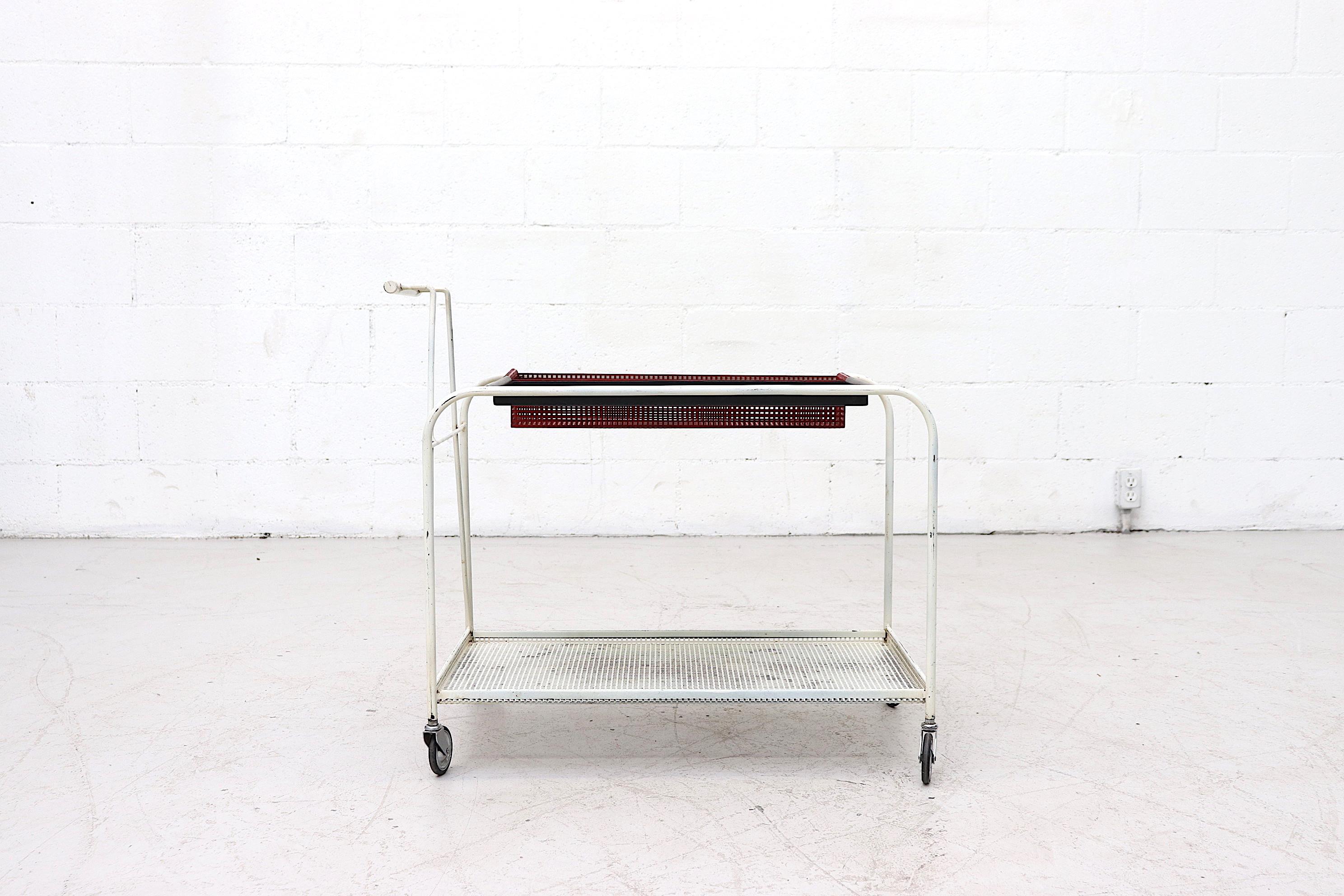 Pilastro rolling serving cart with removable black metal tray and red perforated bottle box. Both interchangeable on white metallic frame with built in perforated lower shelf. Charming design with delicate lines. New period correct wheels. Otherwise