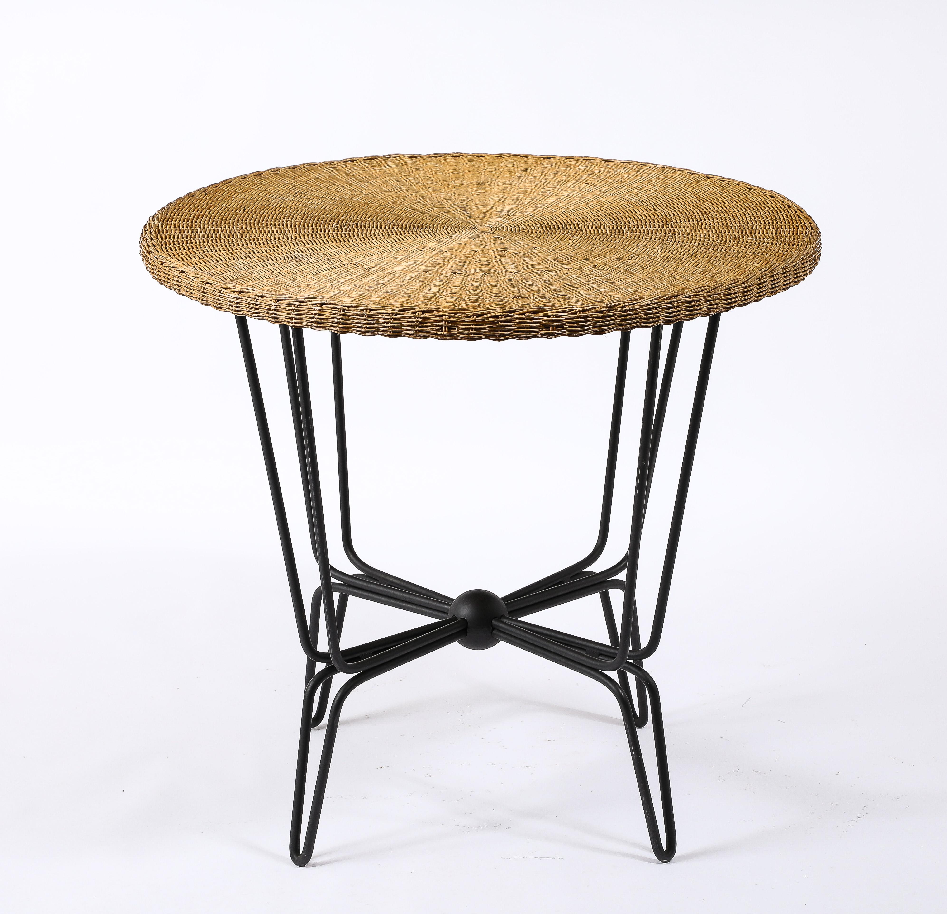 Wicker and wrought iron table by Mathieu mategot. Multi layered rod base with all the rods converging in a central sphere. Finished in a gunmetal patin