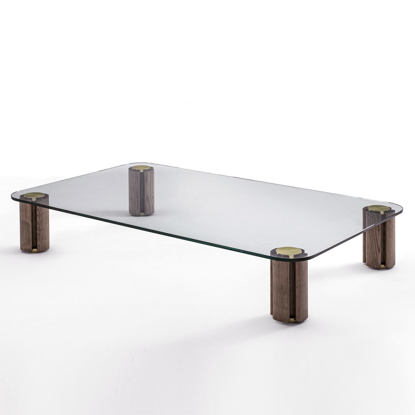 Coffee Table Mathilda rectangular with clear glass top,
15 mm thickness. With 4 feet made with solid walnut wood
with solid brass central poles in brushed finish.
Also available in square coffee table or in side table,
on request.
Also