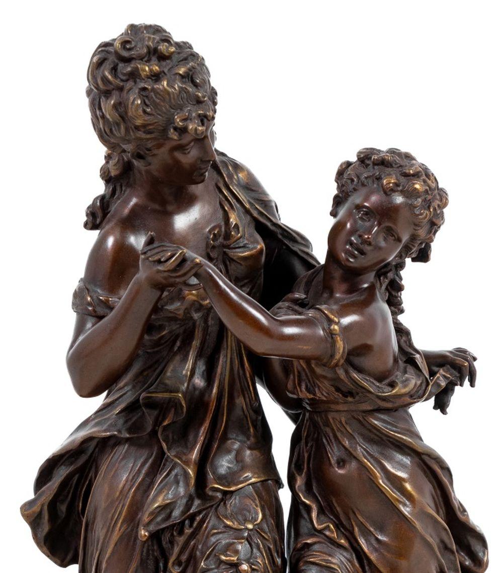 After Mathurin Moreau (French, 1822-1912) Patinated Bronze and White Marble Figural Clock, late 19th century, surmounted by two embracing muses, on a circular base, signed 