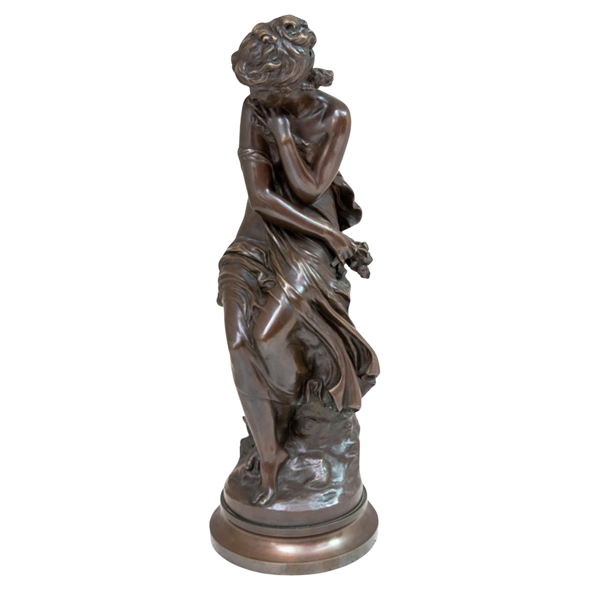 Mathurin Moreau (Français, 1822-1912) Sculpture en bronze patiné représentant une femme assise, fin du XIXe siècle. La figure semi-habillée est assise sur un affleurement rocheux, serrant un bouquet de fleurs, signée, sur un socle circulaire