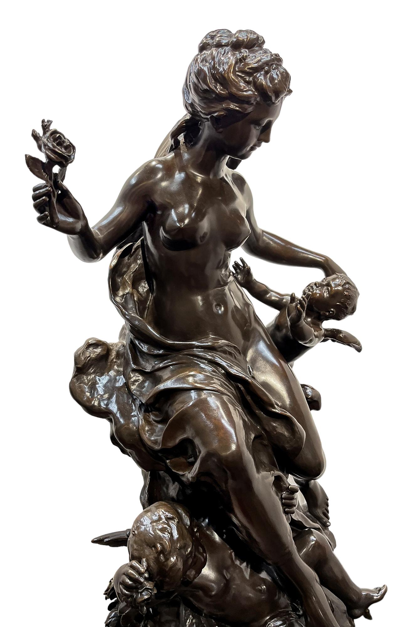 A french patinated bronze figural group of Flora in the sky with Putti and bountiful garlands of flowers. Cast from a model by Mathurin Moreau. Titled 