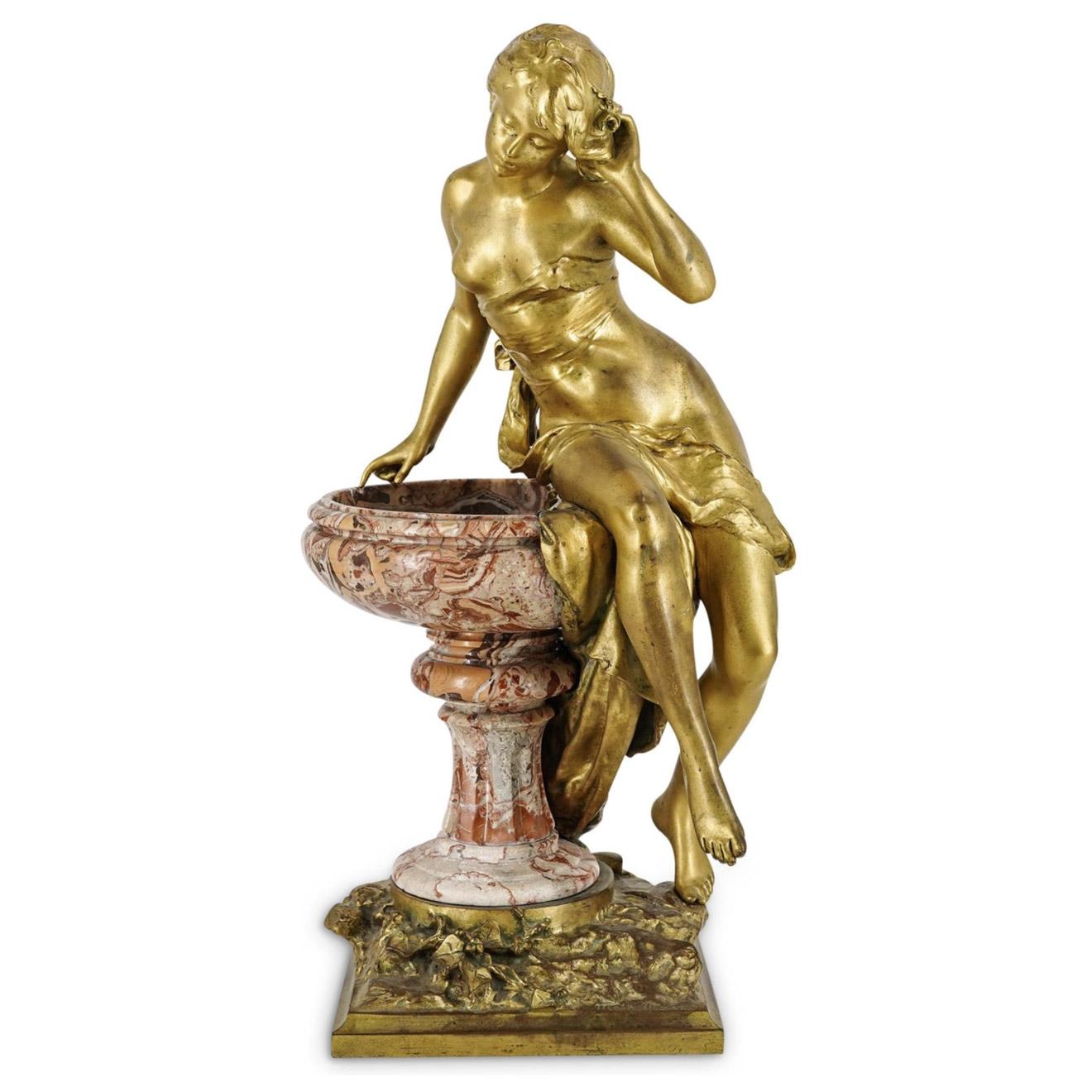 A gilt bronze Female figural sculpture depicting a young woman, slightly unveiled, sitting atop a variegated marble fountain, fitted atop a squared bronze base decorated with foliage. Signed "M. Moureau".

Artist: Mathurin Moreau (1822-1912)
Date: