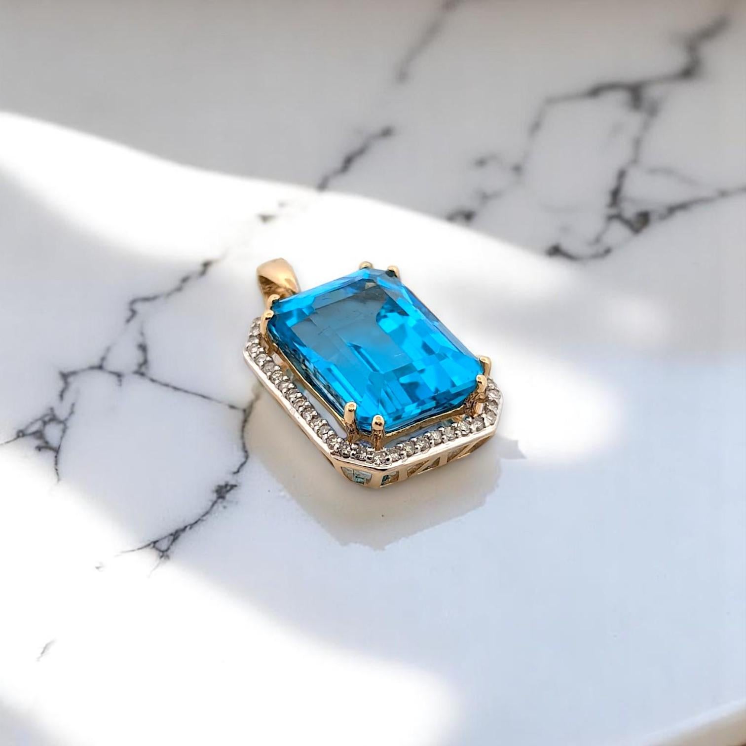 Il Ciondolo Matilda è una splendida vetrina di audace eleganza, con un topazio blu taglio smeraldo di 9,5 carati incastonato in ricco oro giallo 14 carati e impreziosito da 0,20 carati di diamanti naturali. Sospeso su una catena d'oro da 18 pollici,