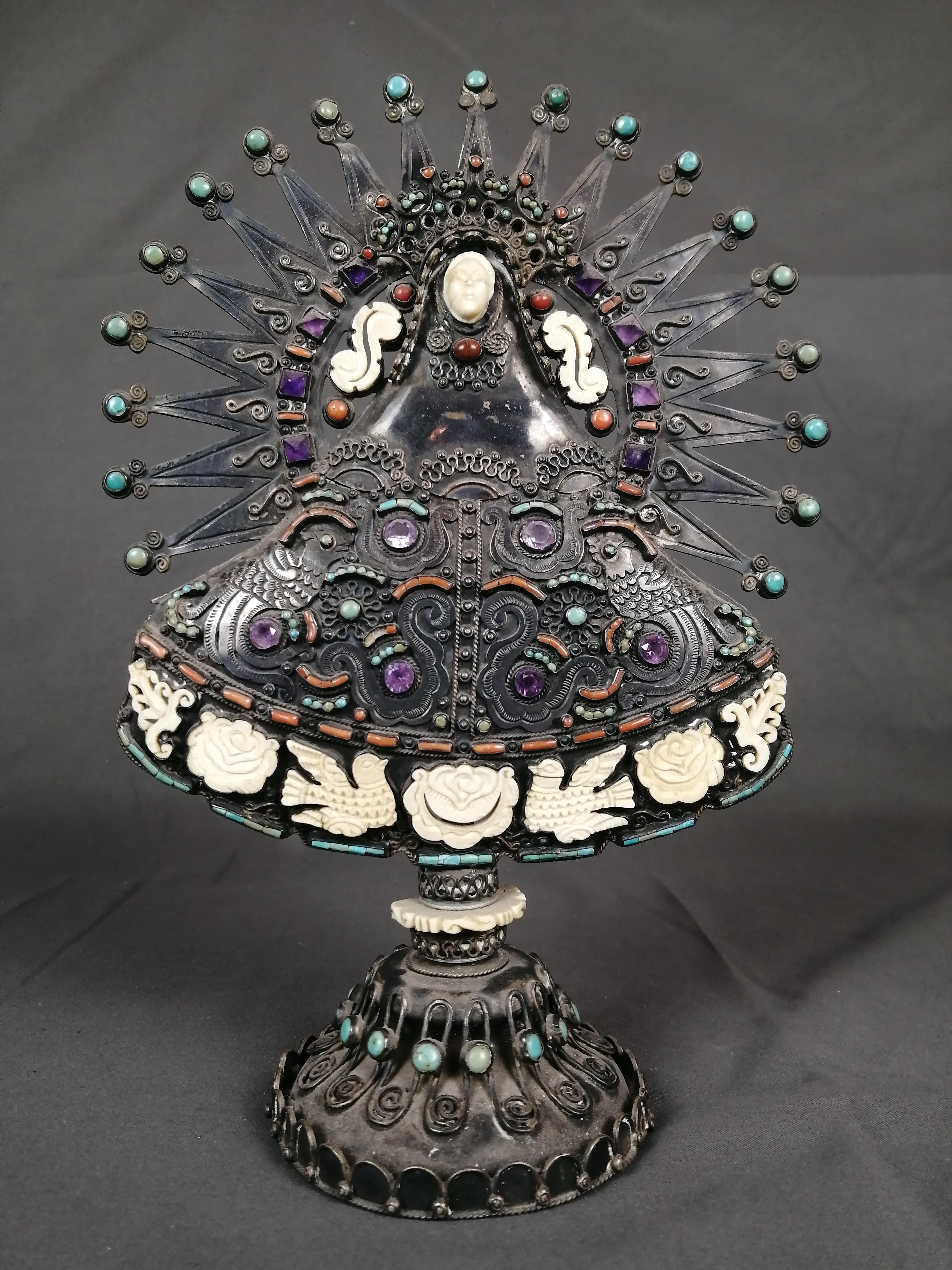 Una rara escultura de la Virgen María de ca. 1945 en plata 0,930 con hueso tallado, amatista y turquesa, obra de la platera mexicana Matilde Poulat. Fabricado en Taxco, Guerrero, México. El vestido plateado 