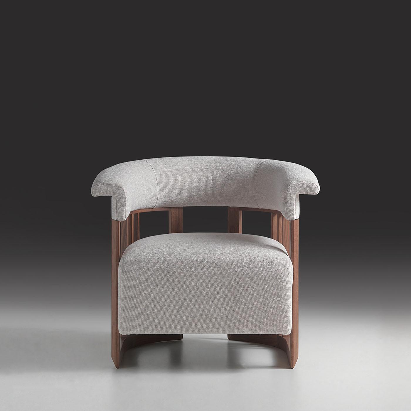 The Matilde armchair features a curved backrest supported by vertical slats, creating an open and elegant silhouette. Upholstered in soft ZR Infinity Soft 10711-811 fabric, this medium-sized chair combines comfort with refined design. The walnut