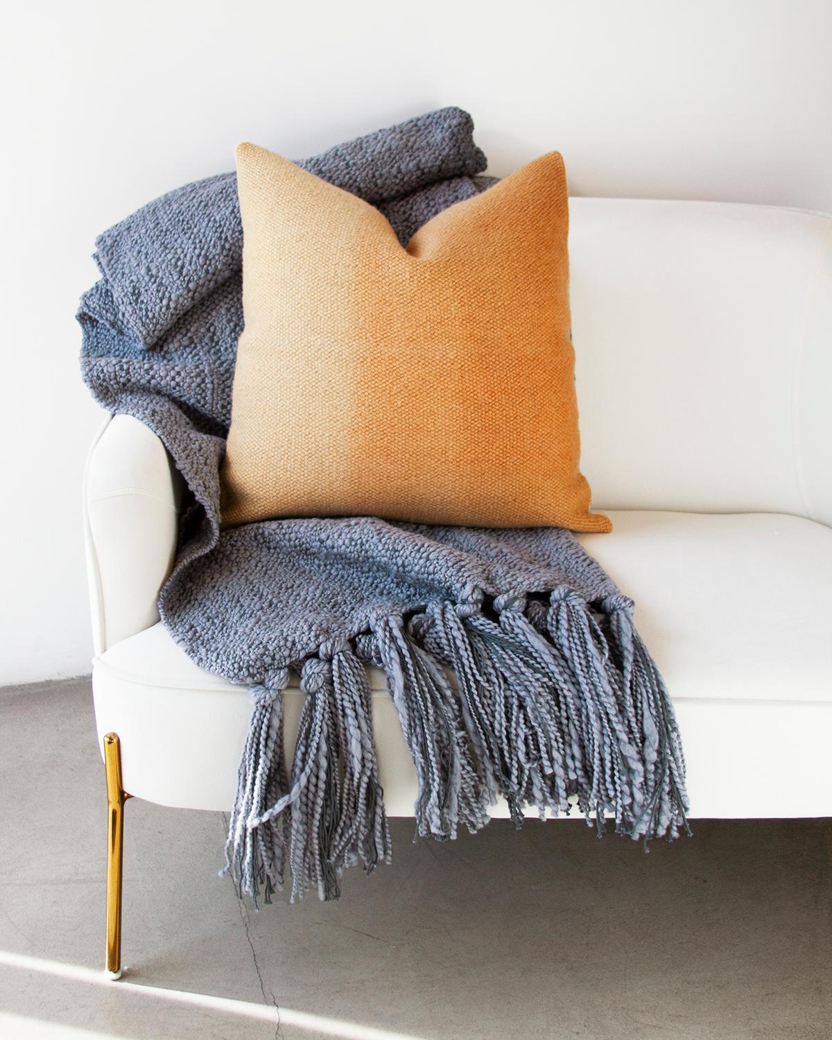 Add some color to your couch. This Matiz Gold Ombre Throw Pillow provides a unique way to add organic modern style to your home décor. Hand-woven from sheep wool, the ombre effect is achieved with plant dyes in amber yellow and orange hues that give