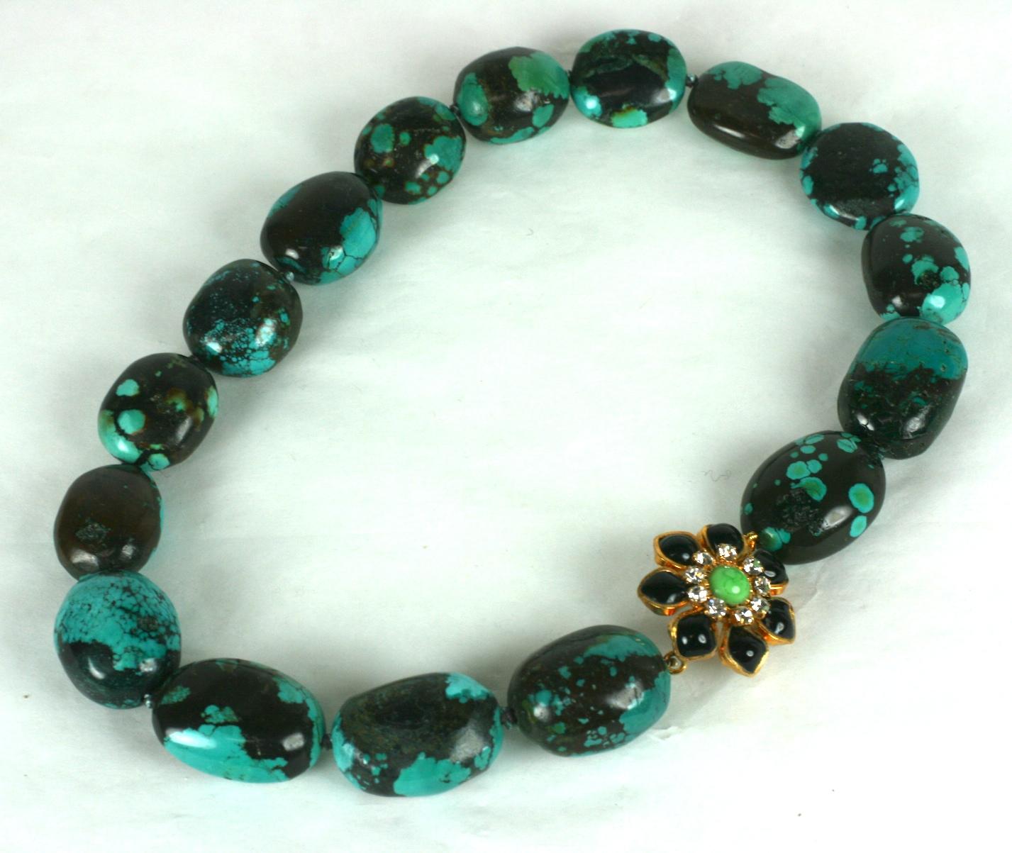 Matrix turquoise hand knotted oval beads with hand made poured glass Marguerite floral clasp in jet and vibrant jade poured glass enamel with crystal rhinestone accents. Hand made in our studios in France. 
MWLC 